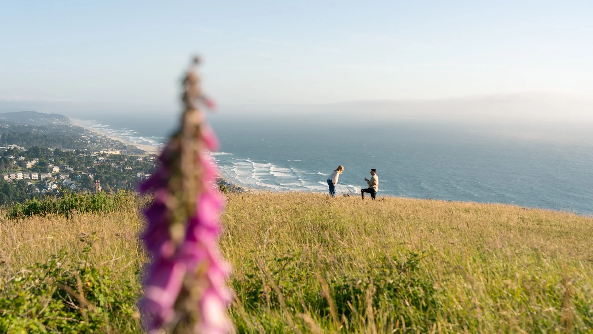 a boyfriend proposing to his girlfriend at the top of The Knoll in lincoln city oregon on the hike towards God's Thumb