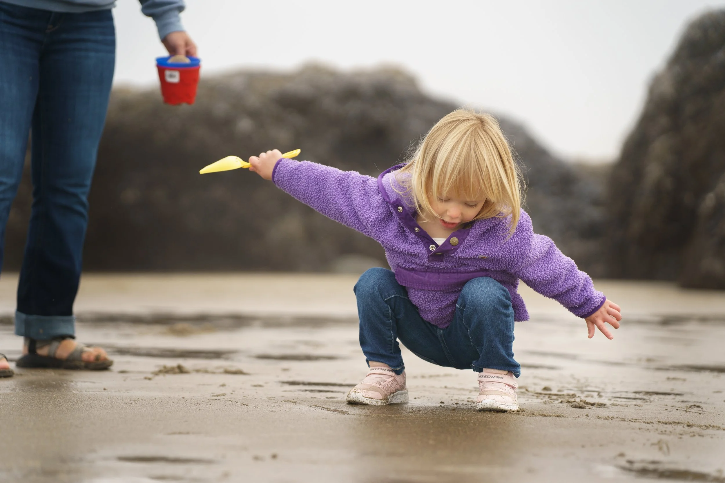 young girl playing in the sand on the oregon coast