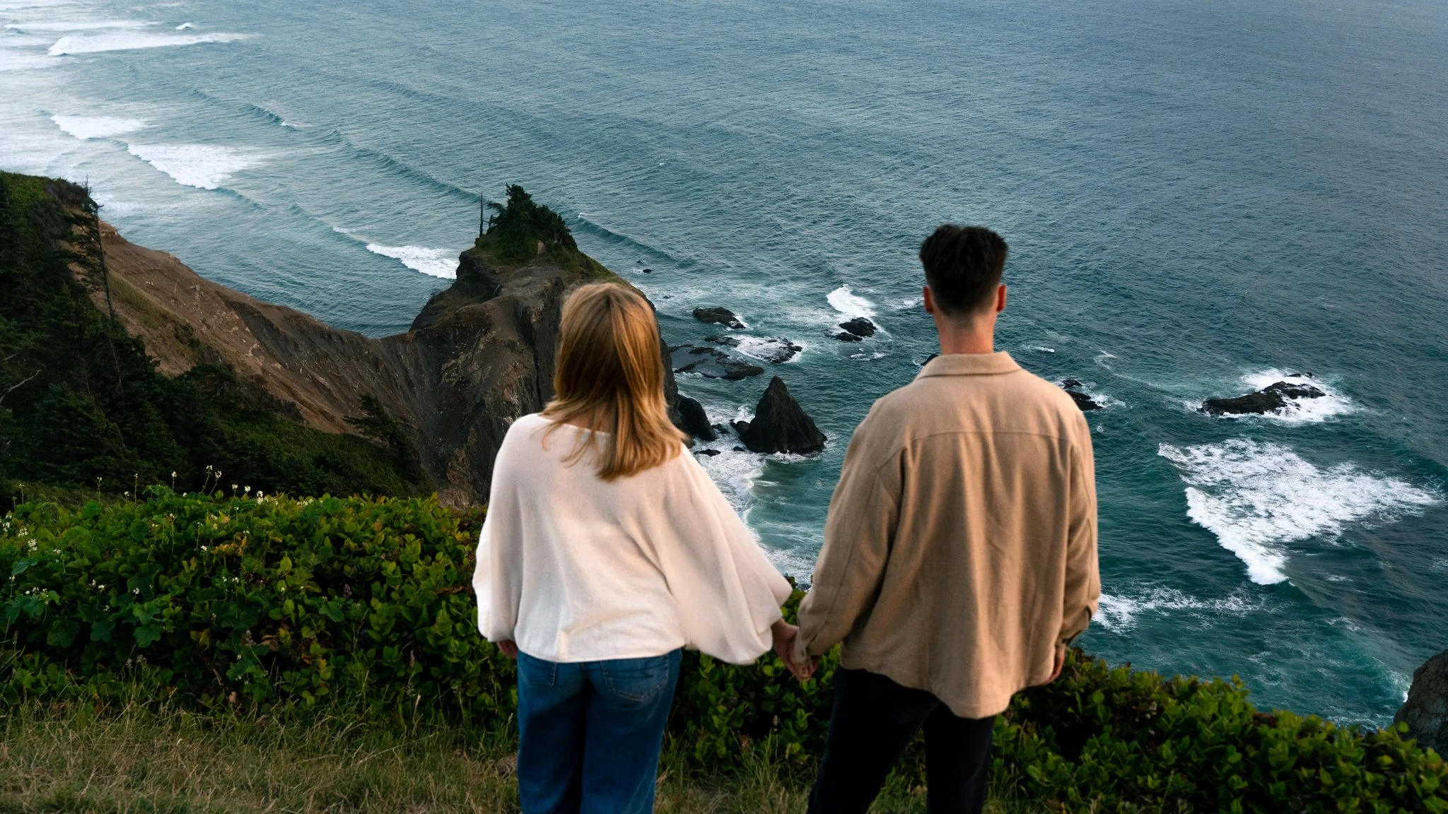 A couple standing on the top of God's Thumb after their proposal in Lincoln City Oregon