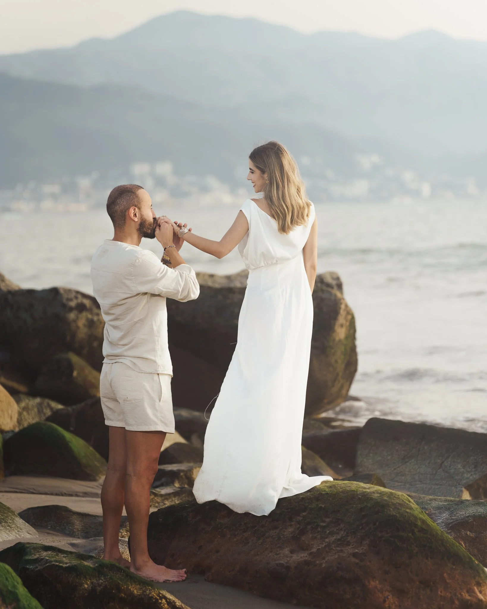 couple standing on a beach with their engagement photographer