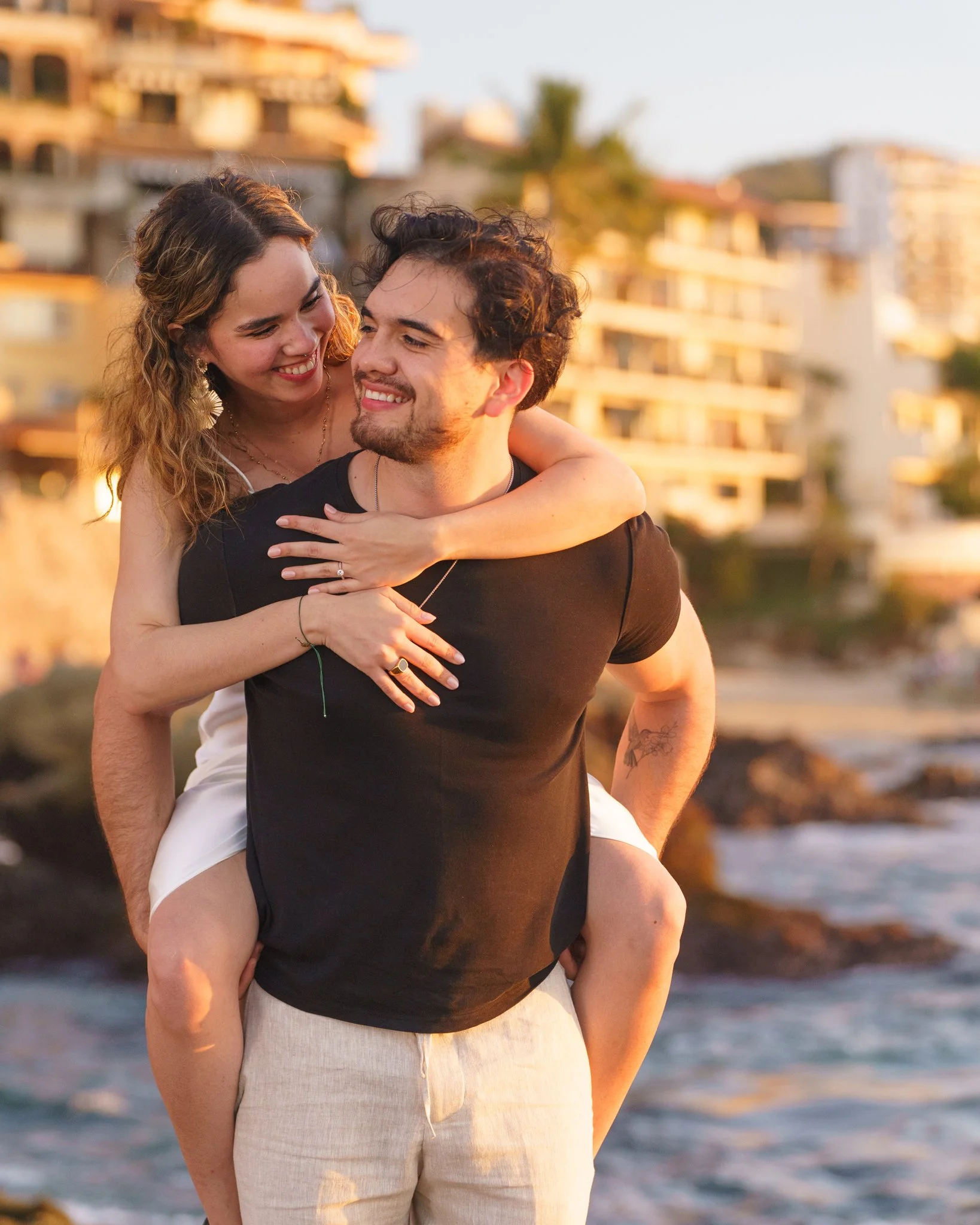 a couple does a piggy back ride during a session with thier engagement photographer