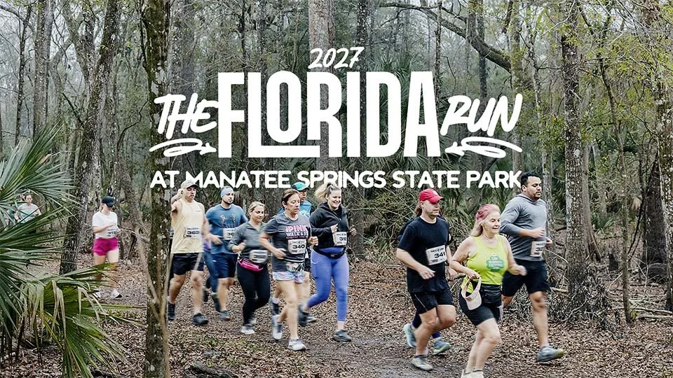 Group of runners participating in The Florida Run 2027 at Manatee Springs State Park, jogging along a wooded trail surrounded by trees, with event title text overlaid on the image.