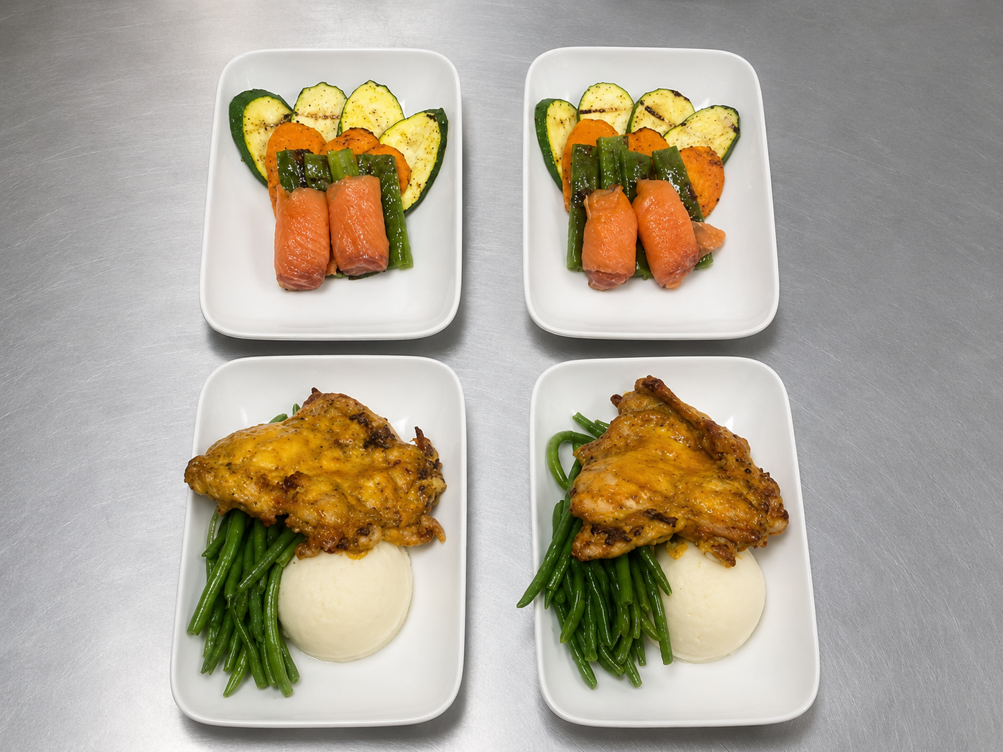 Four plated airline meals.png