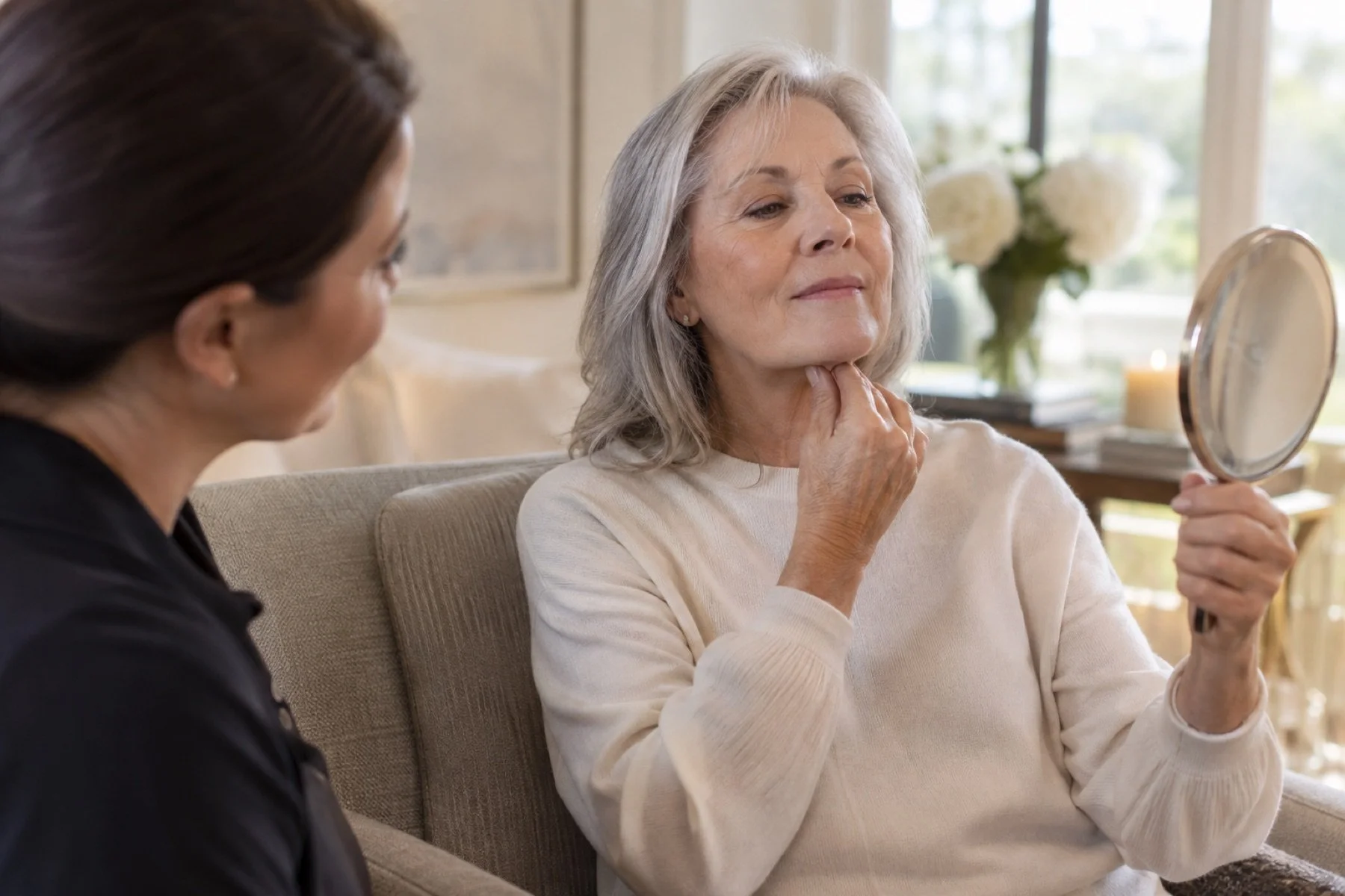 Older adult practicing gentle jaw and neck movement with her physical therapist during individualized orofacial physical therapy at home.