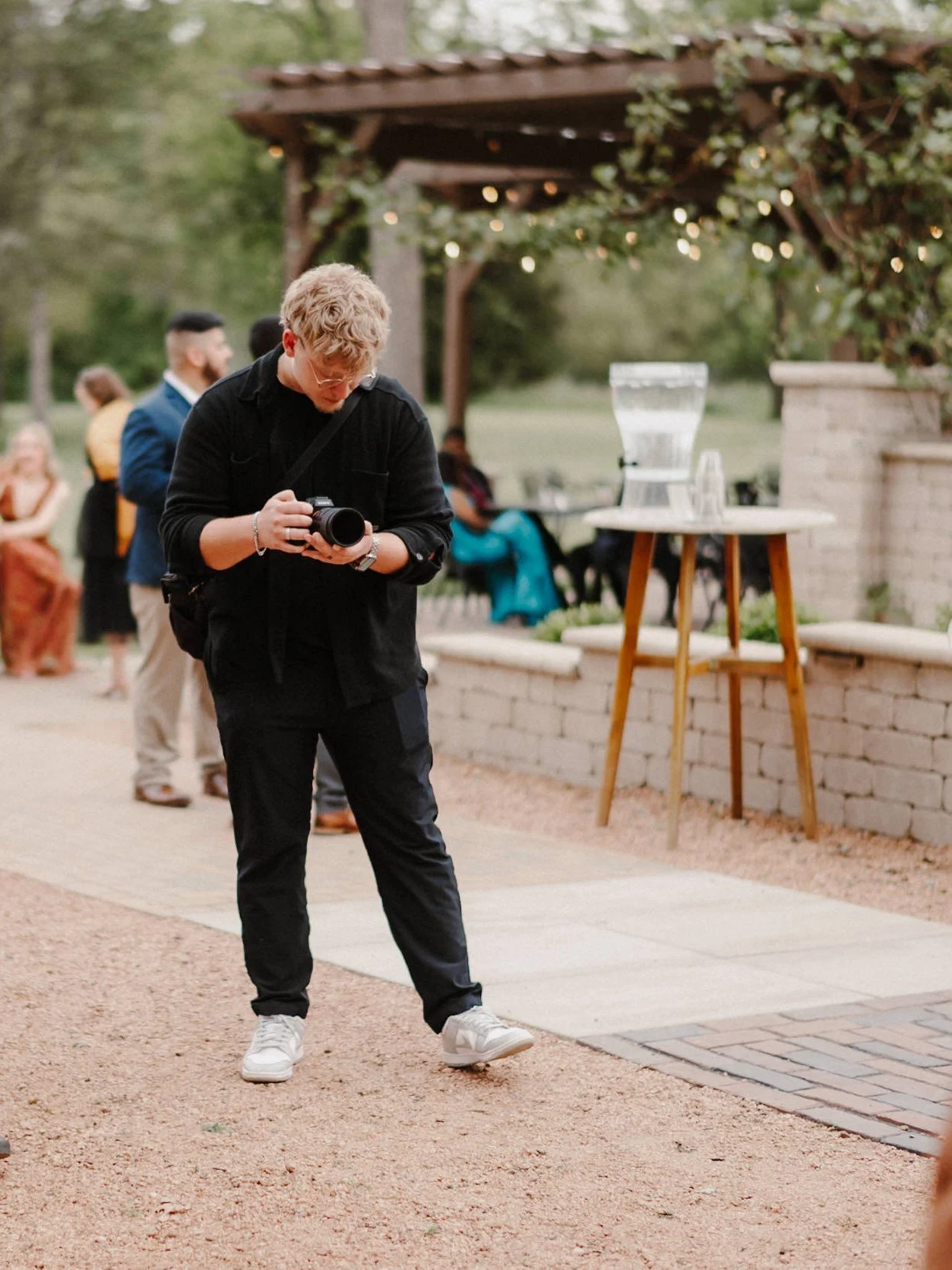 Wedding videographer filming guests at an outdoor reception