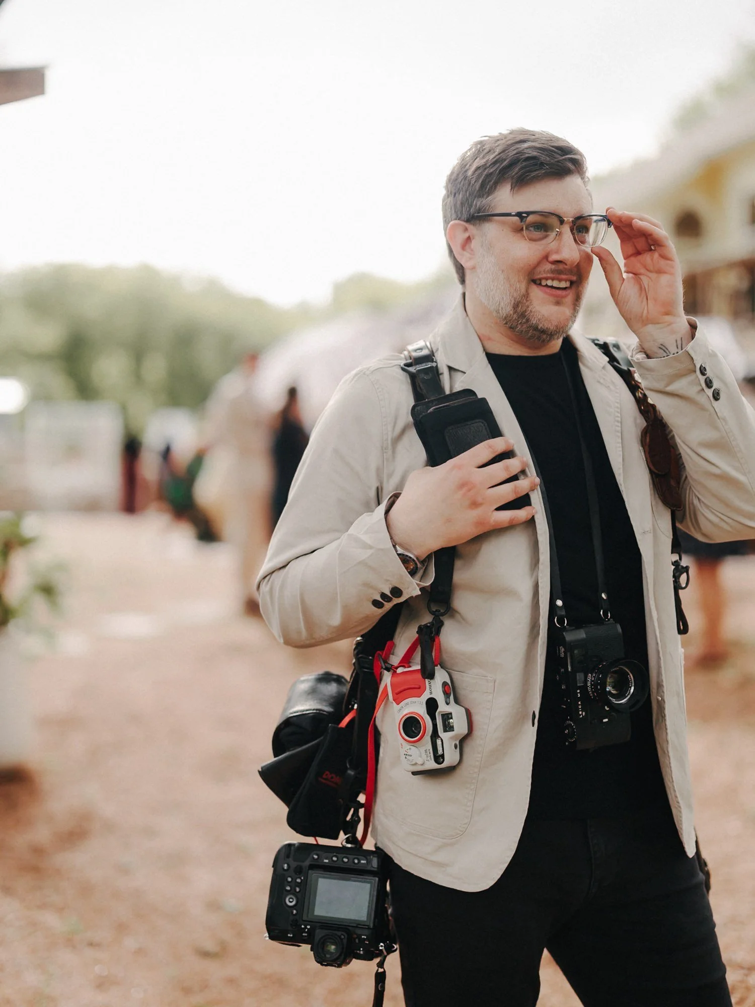Associate photographer at a wedding carrying a Leica and 35mm film cameras