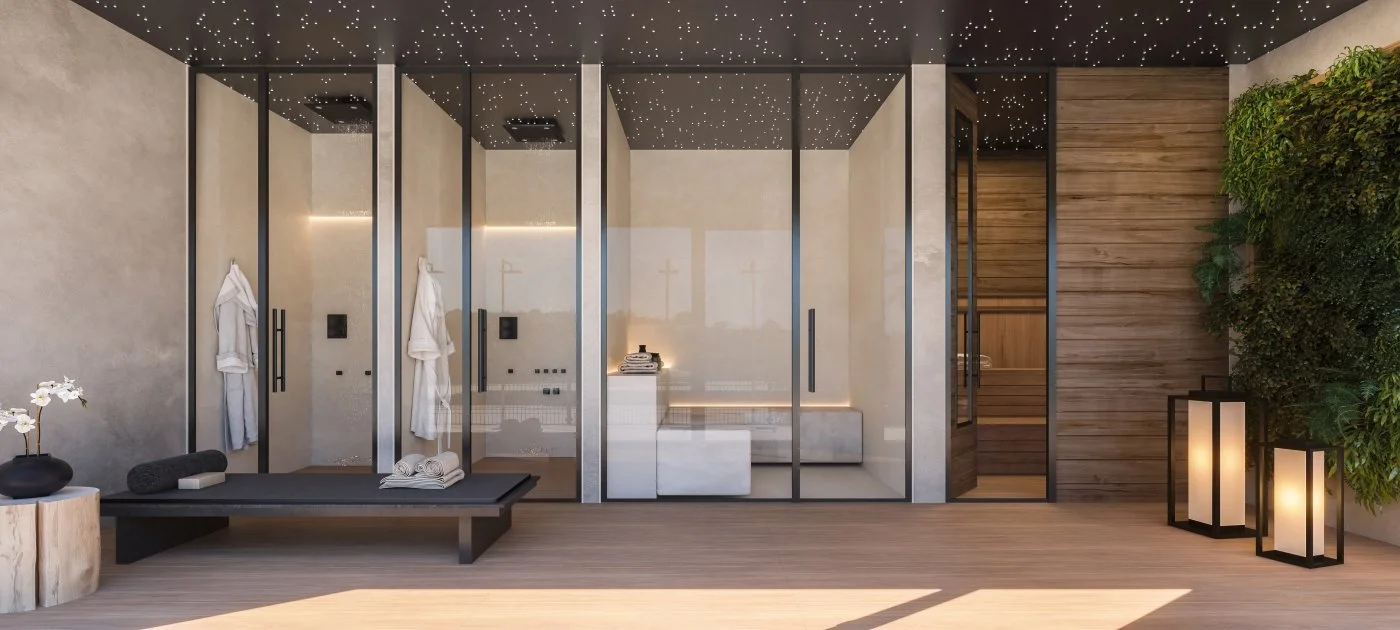 Modern indoor spa room with glass enclosures, wooden accents, and soft lighting, featuring robes and towels, with a bench, potted plants, and lanterns.