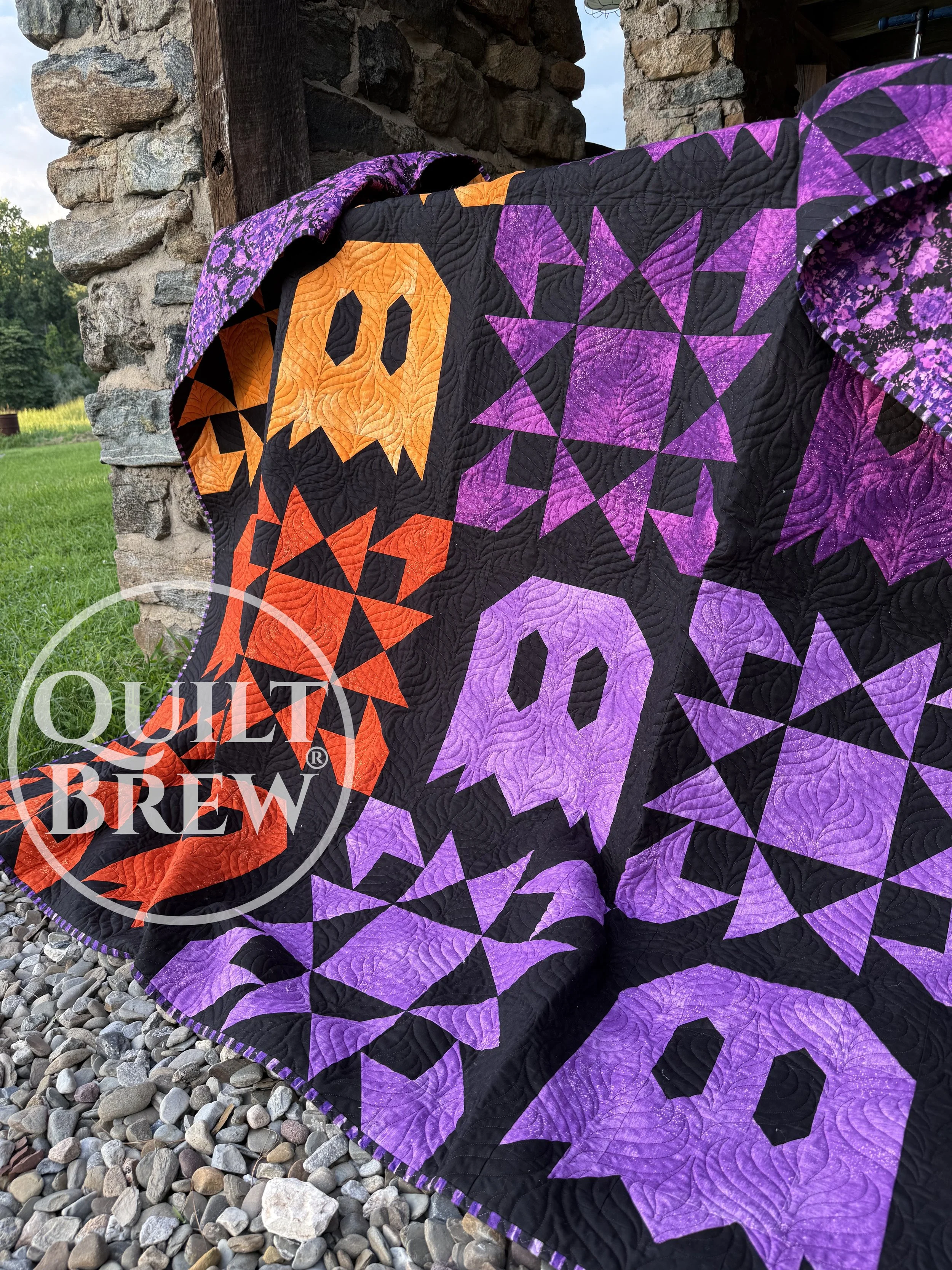 Image of a ghost quilt with stars hanging on a stone barn.