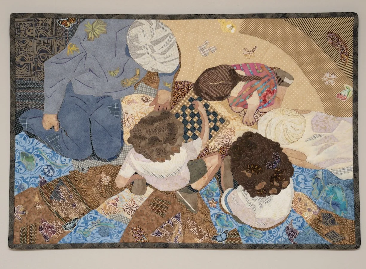 We are looking down from above at one adult and four children that are huddled around a checkers board. The floor is a fictional combination of images that suggest animals and plants of the world.