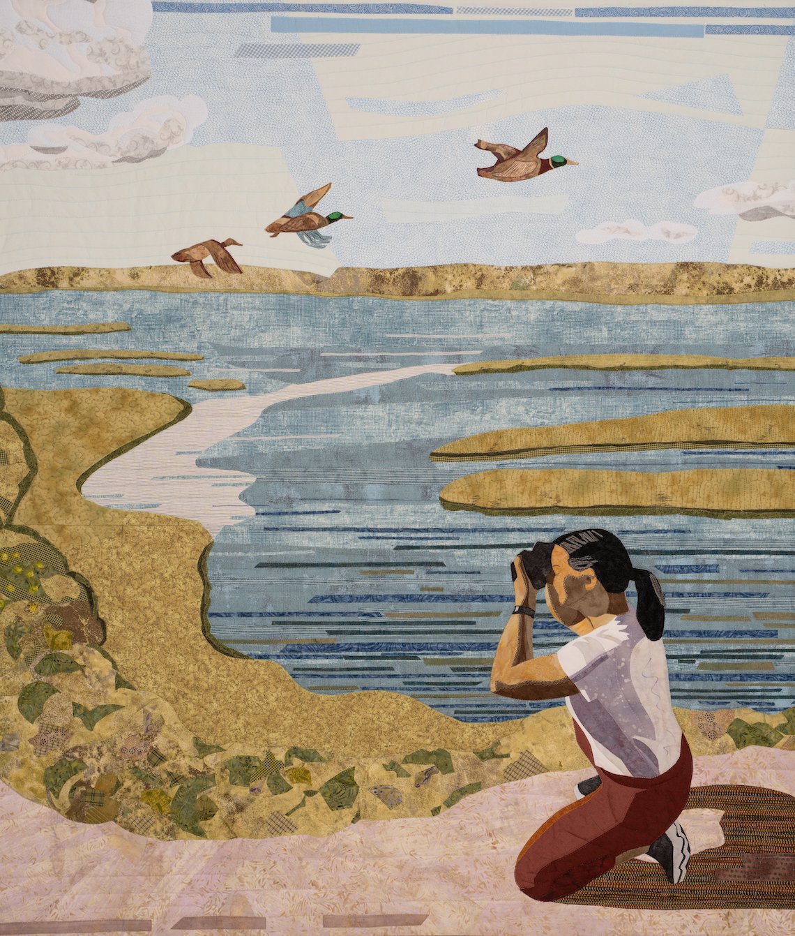 detail showing sky, ducks, water, and photographer kneeling.