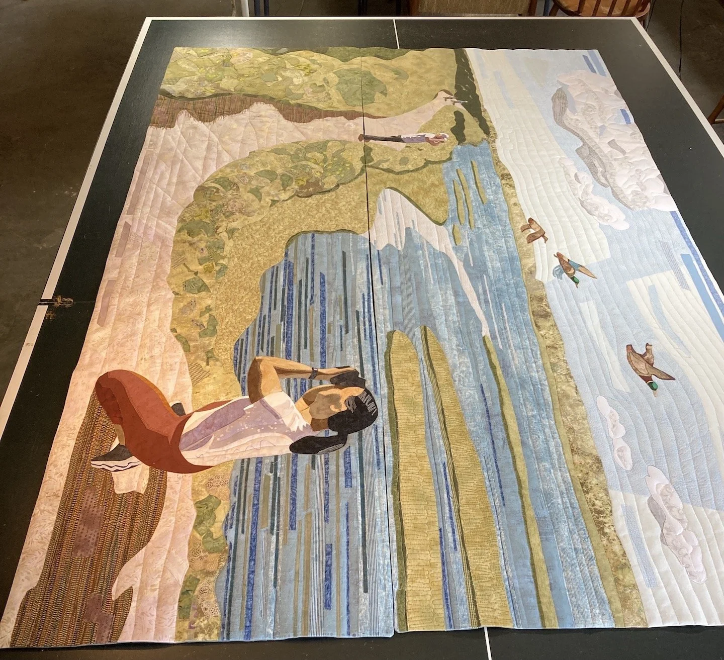 Two quilts placed together, ready to be stitched together by hand.