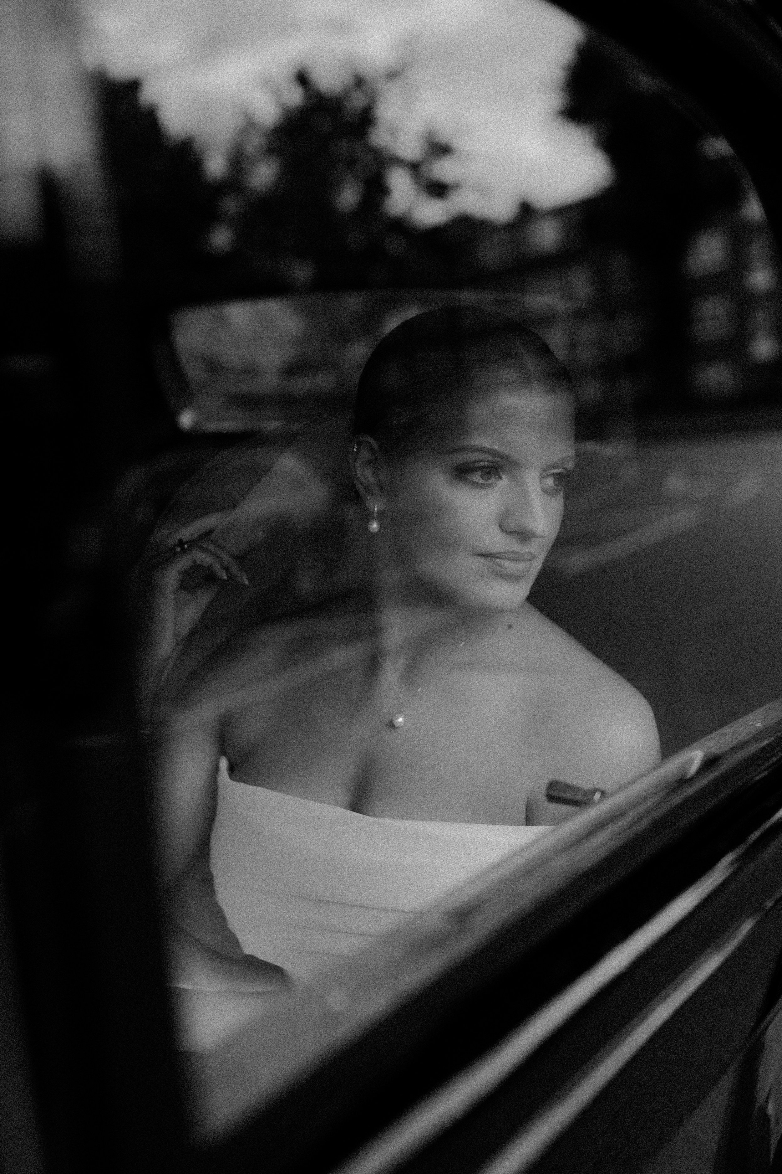 Black and white photograph of a bride in her wedding car 