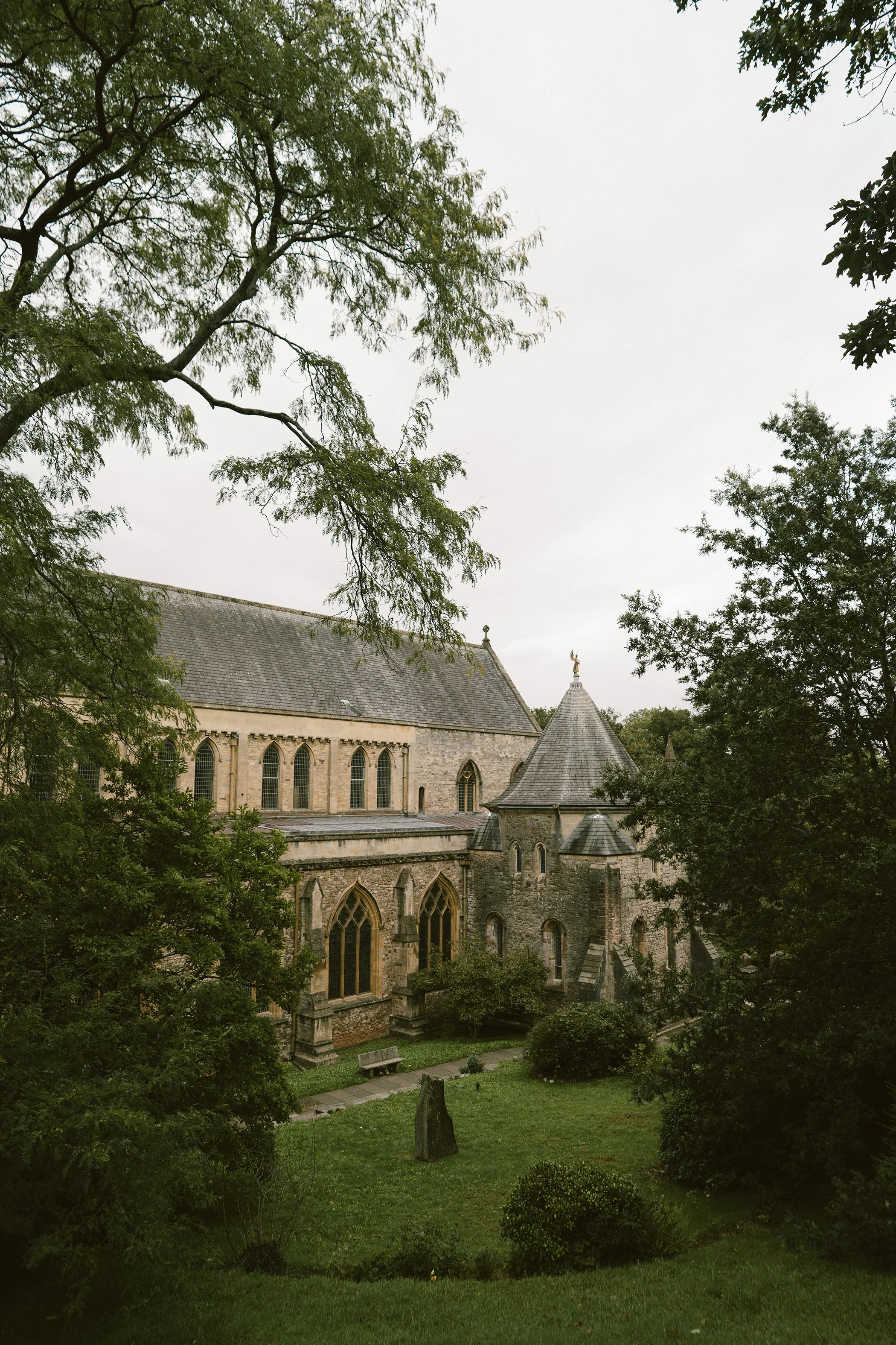 A church surrounded by trees and a green lawn.