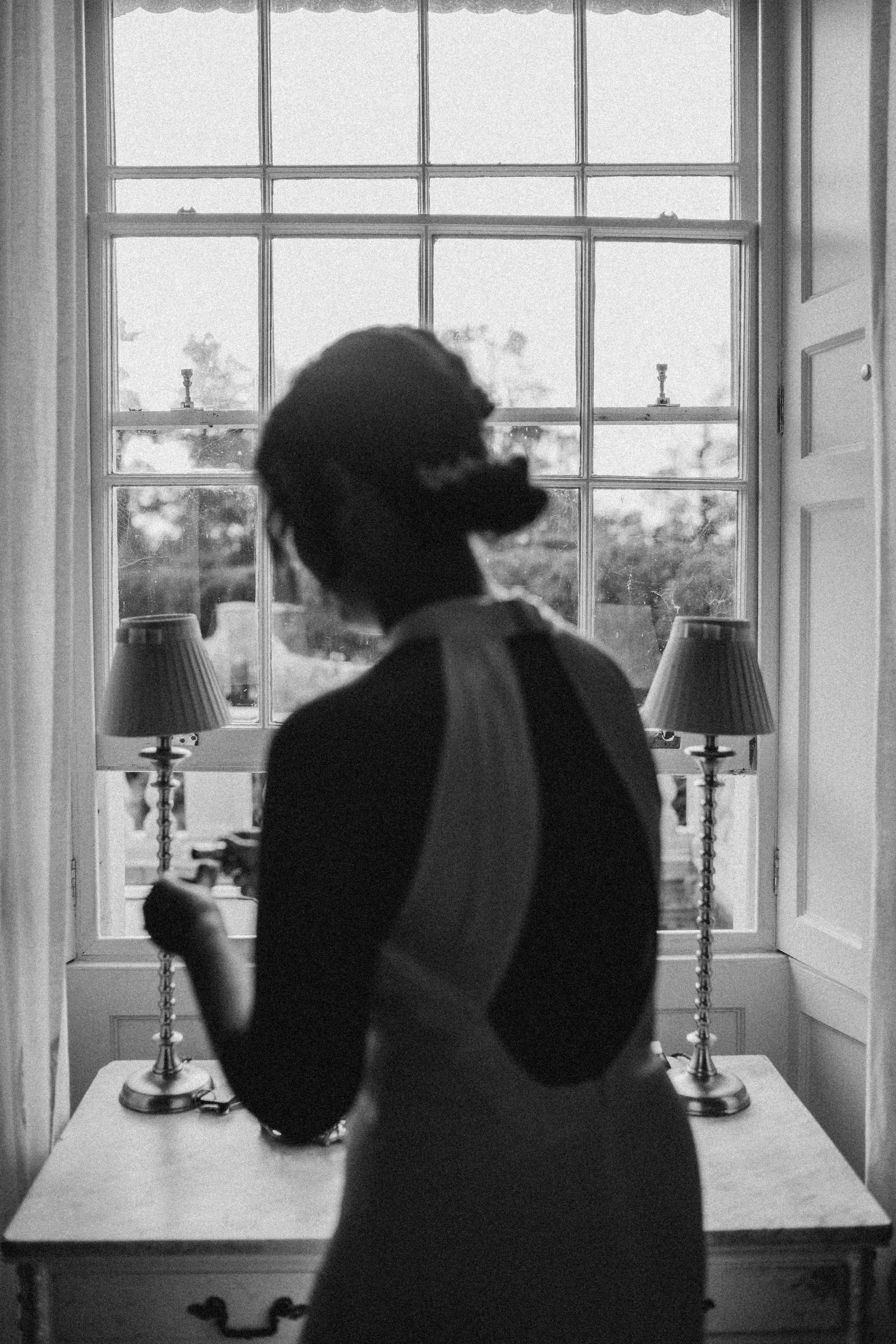Bride getting ready in front of window at Gilseton Manor in Wales