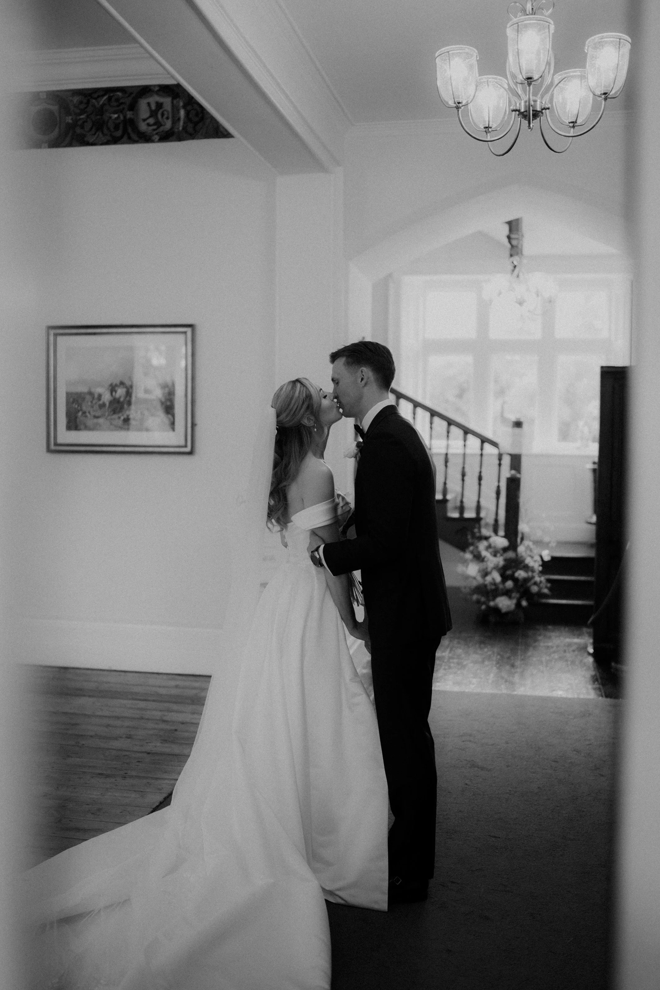A bride and groom kissing inside a decorated house during their wedding.