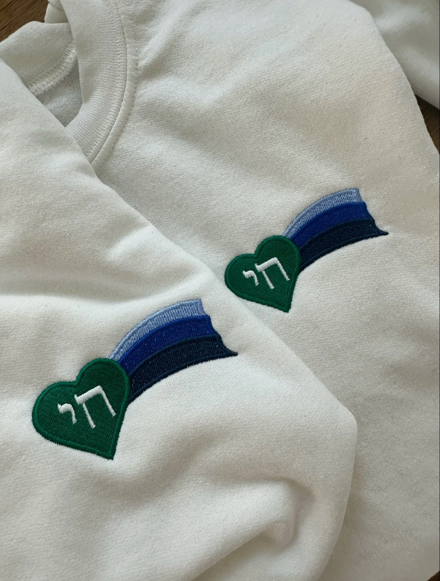 A closer look: our logo is a symbol rooted in connection, designed with intention, and created to be worn with strength and a profound sense of belonging. Every stitch carries the spirit of Chai Vekayam - community, continuity, and living boldly.