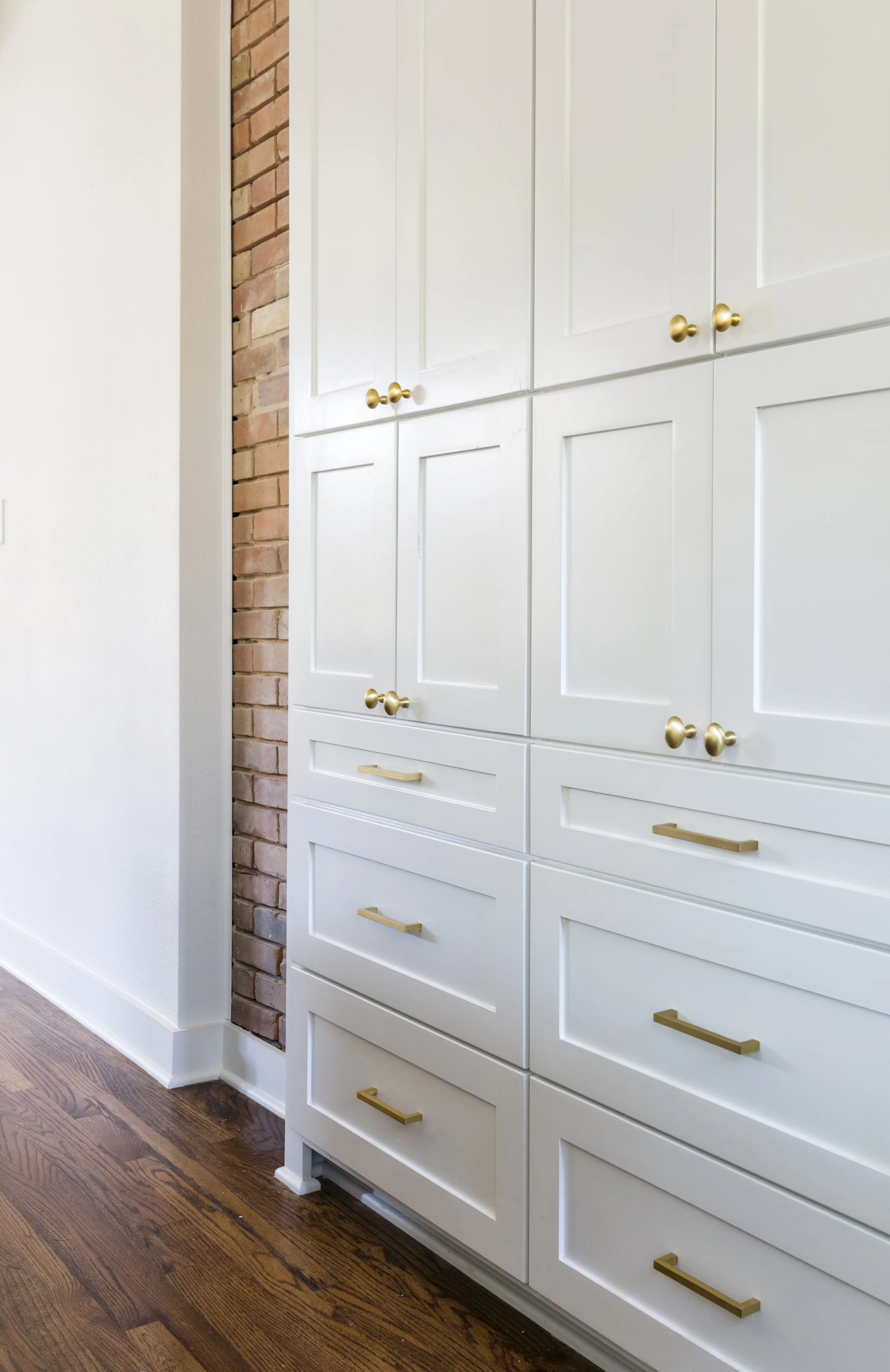 wall size White cabinet by golden handles