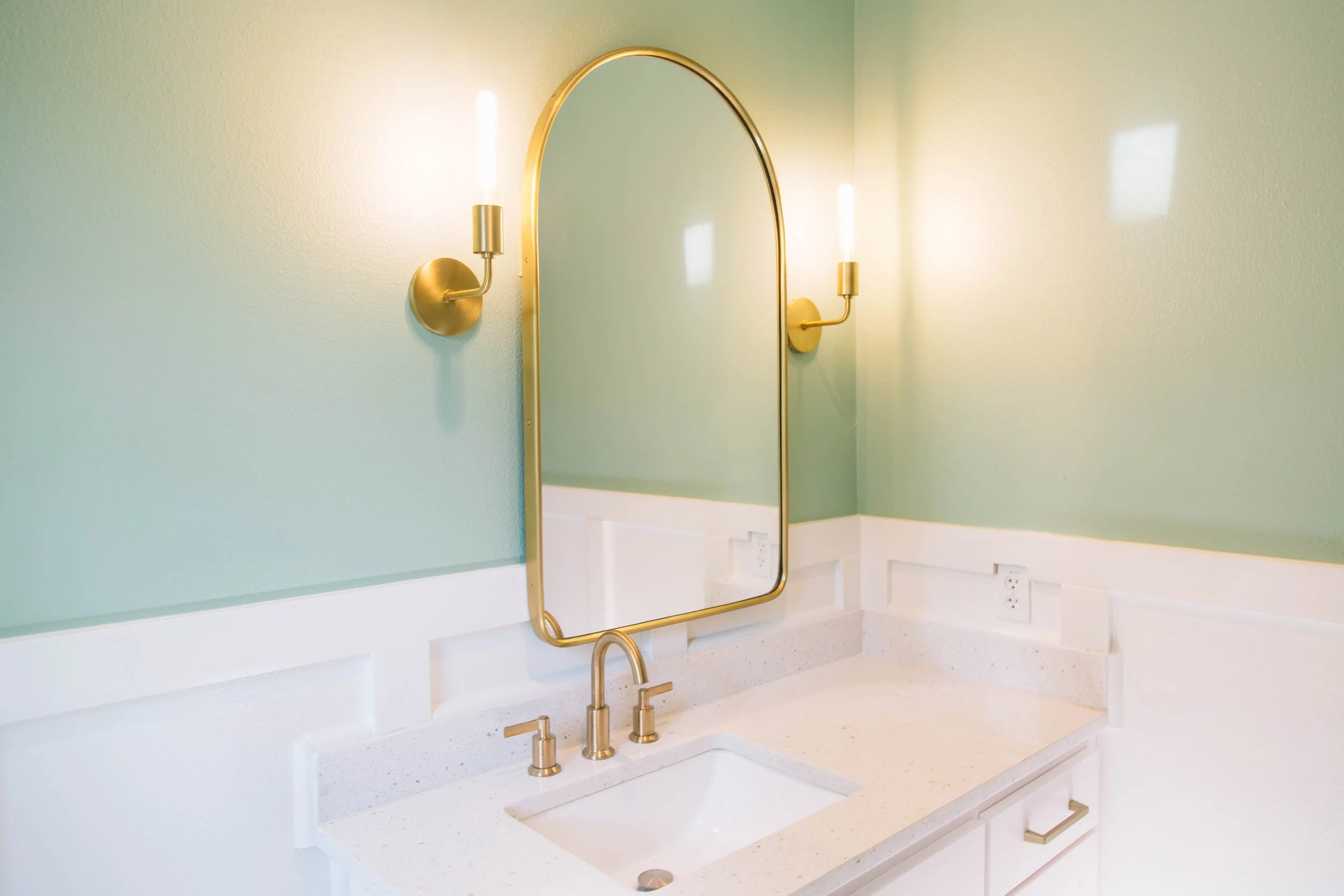 Stylish mirror above sink with soothing color on wall
