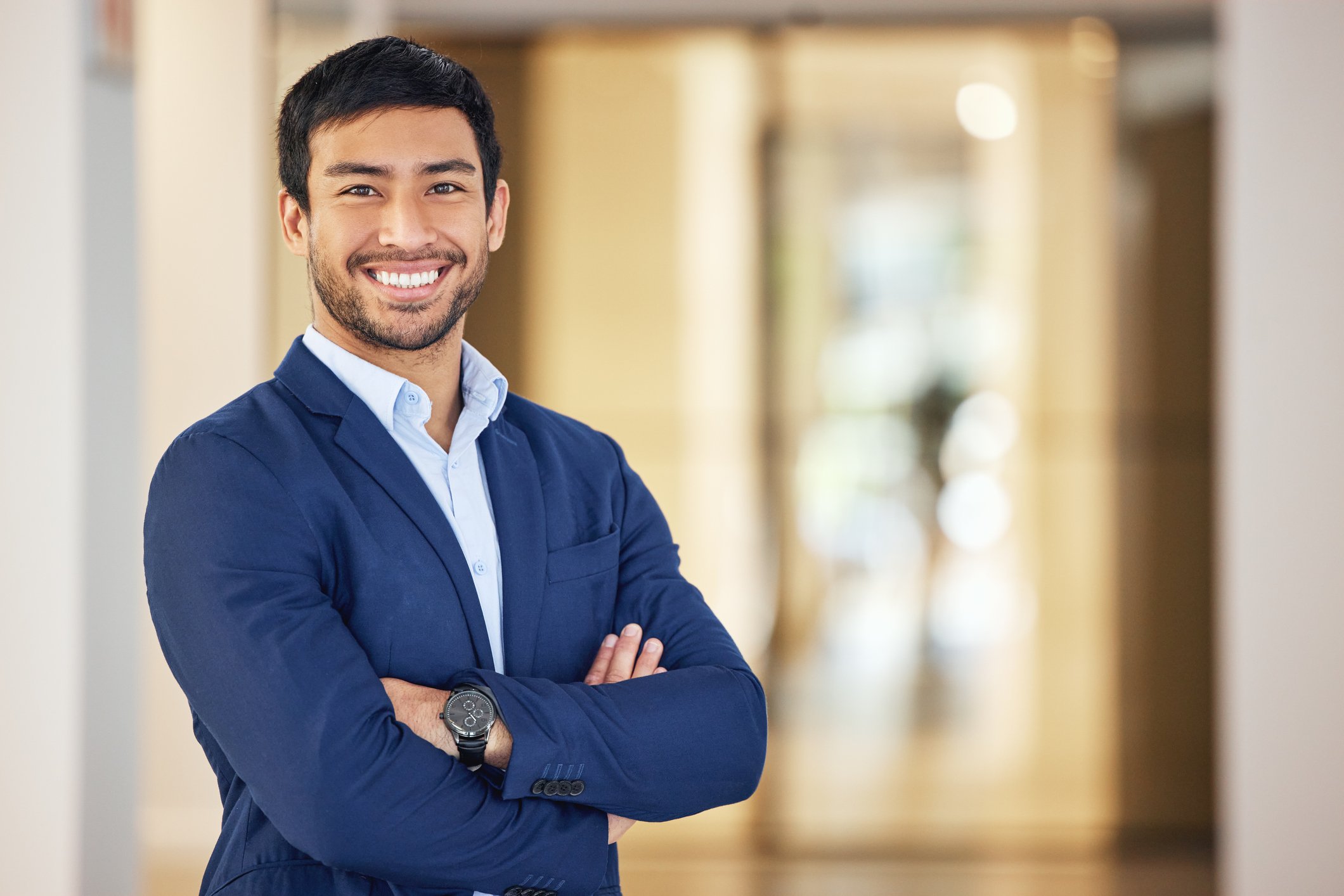 Smiling man in a blue suit with arms crossed