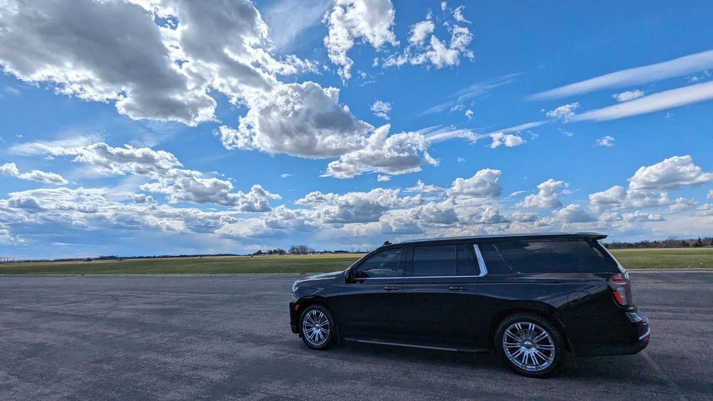 For Sure Luxury 2025 Limo Custom Suburban parked on an airport ramp under a blue sky
