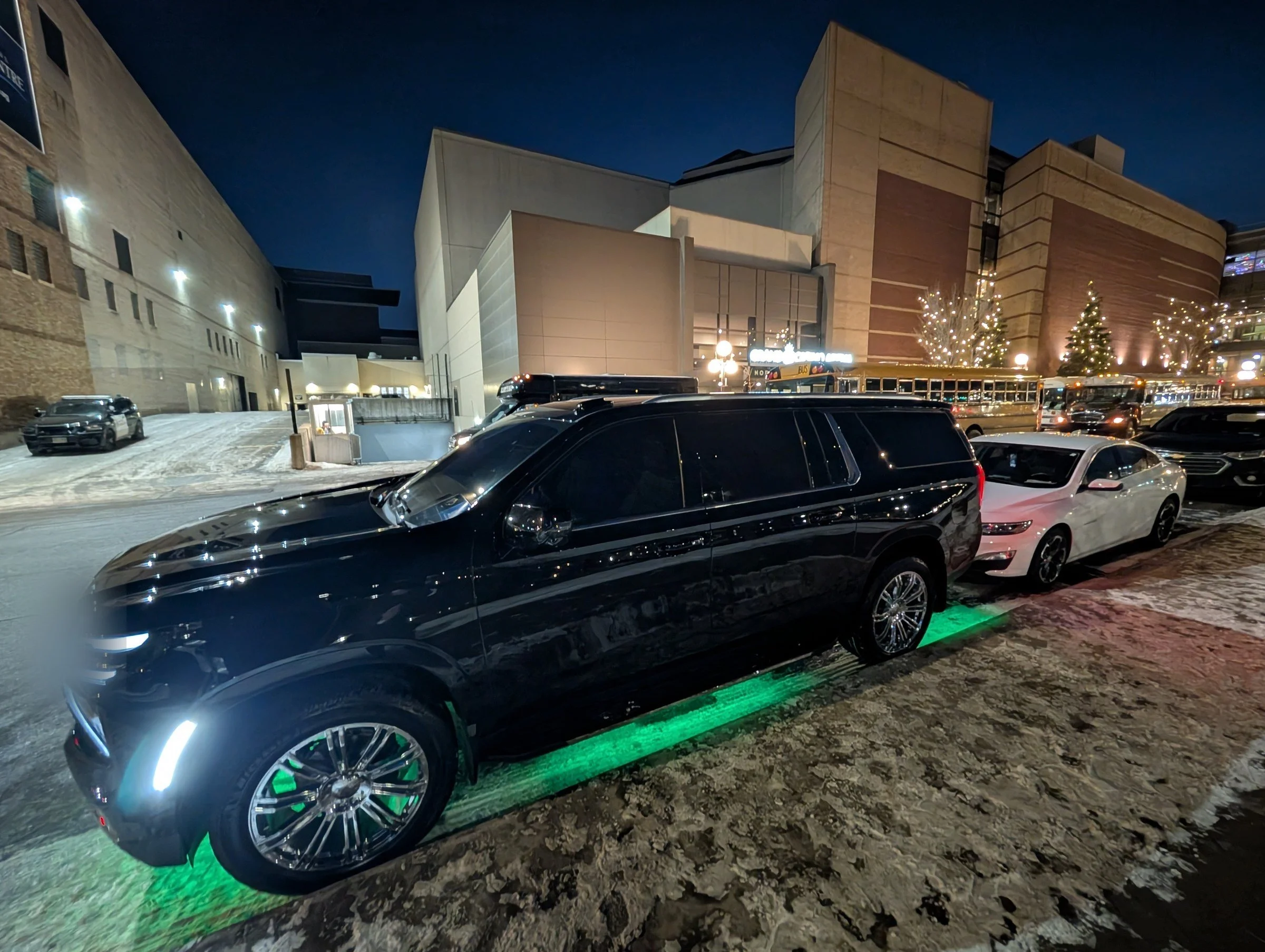 For Sure Luxury 2025 Limo Custom Suburban with ambient underglow outside Target Center in downtown Minneapolis at night