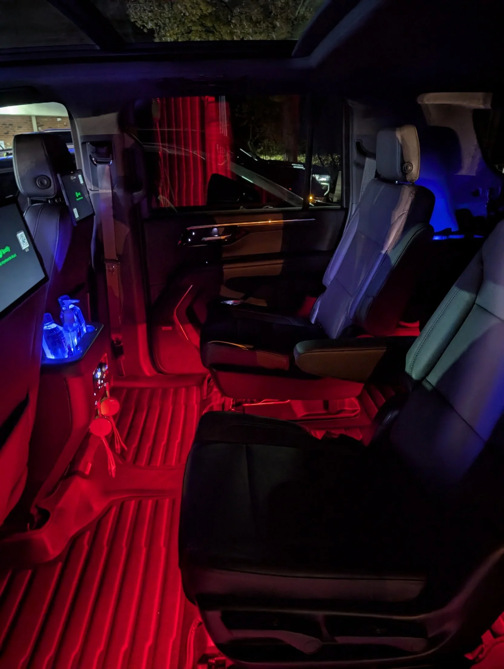 Captain's chairs and ambient lighting inside the For Sure Luxury 2025 Limo Custom Suburban for hourly charters