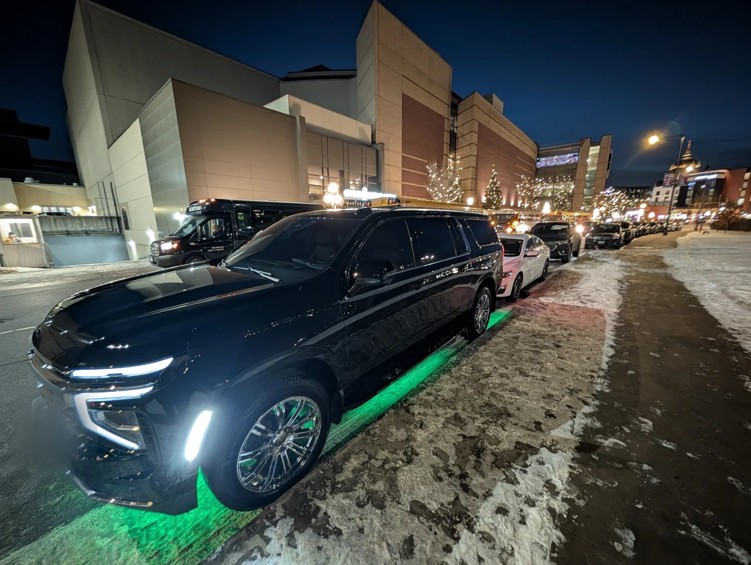 Black luxury SUV in downtown Minneapolis at night