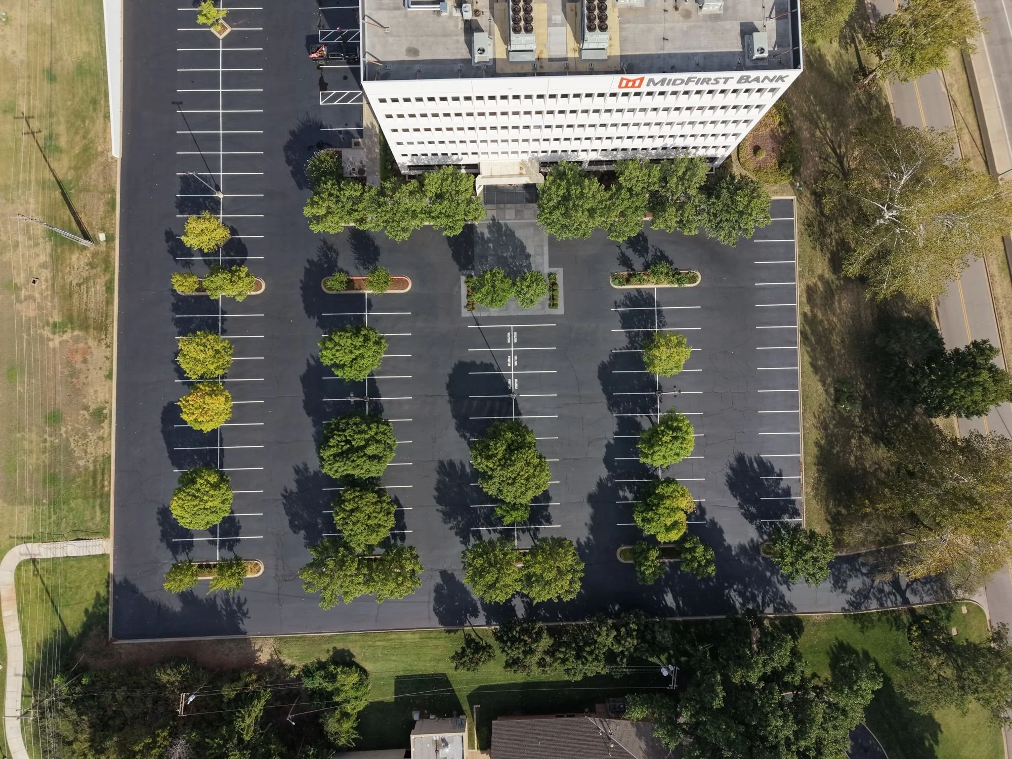 Aerial view of a striped parking lot with tree islands at a MidFirst Bank corporate office in Oklahoma City