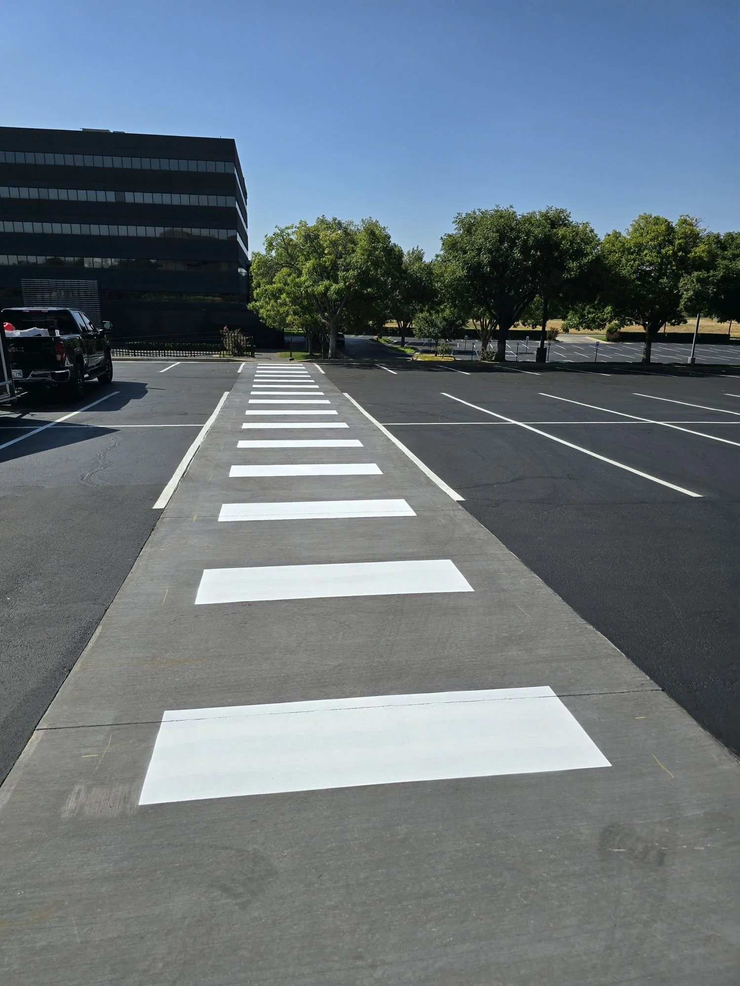 Freshly sealcoated commercial parking lot with new crosswalk and stall striping in Oklahoma City