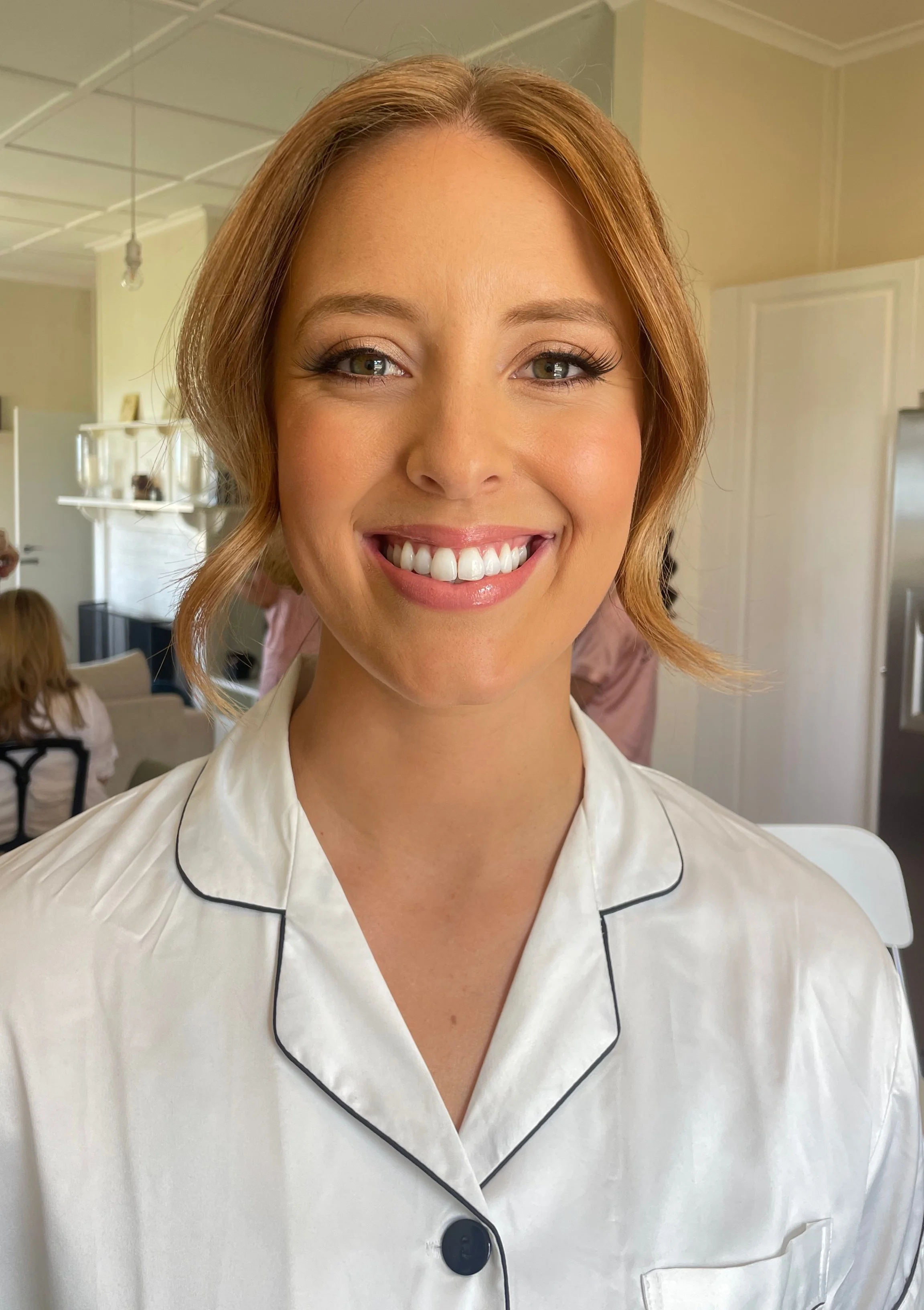 Smiling bridesmaid after having her makeup professionally applied