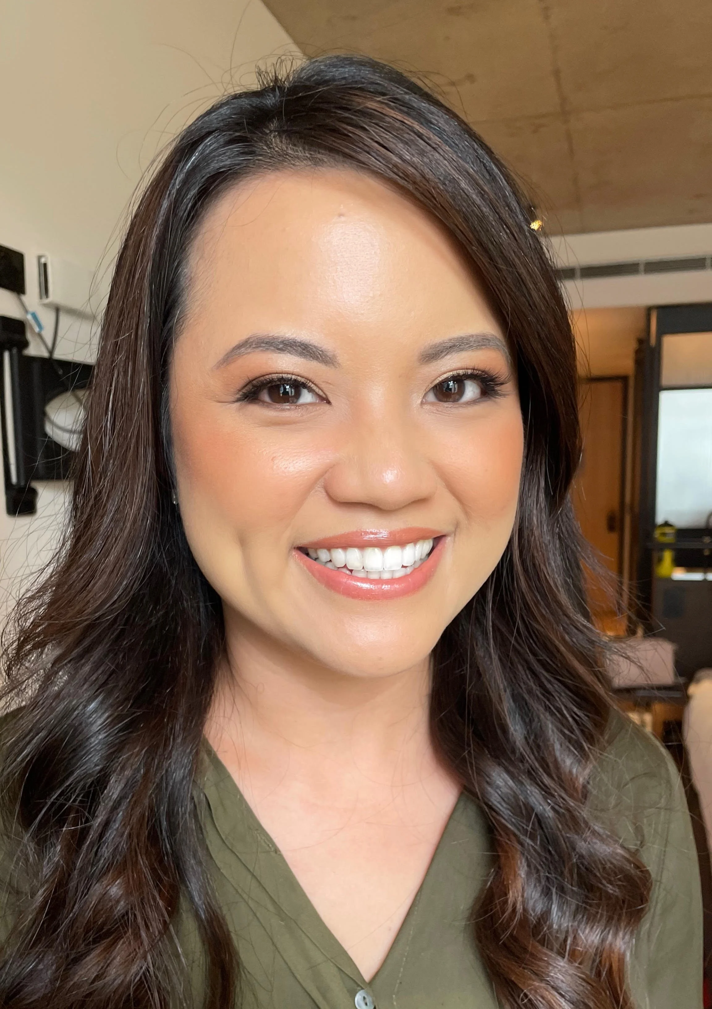 Smiling bridesmaid after having her makeup professionally applied