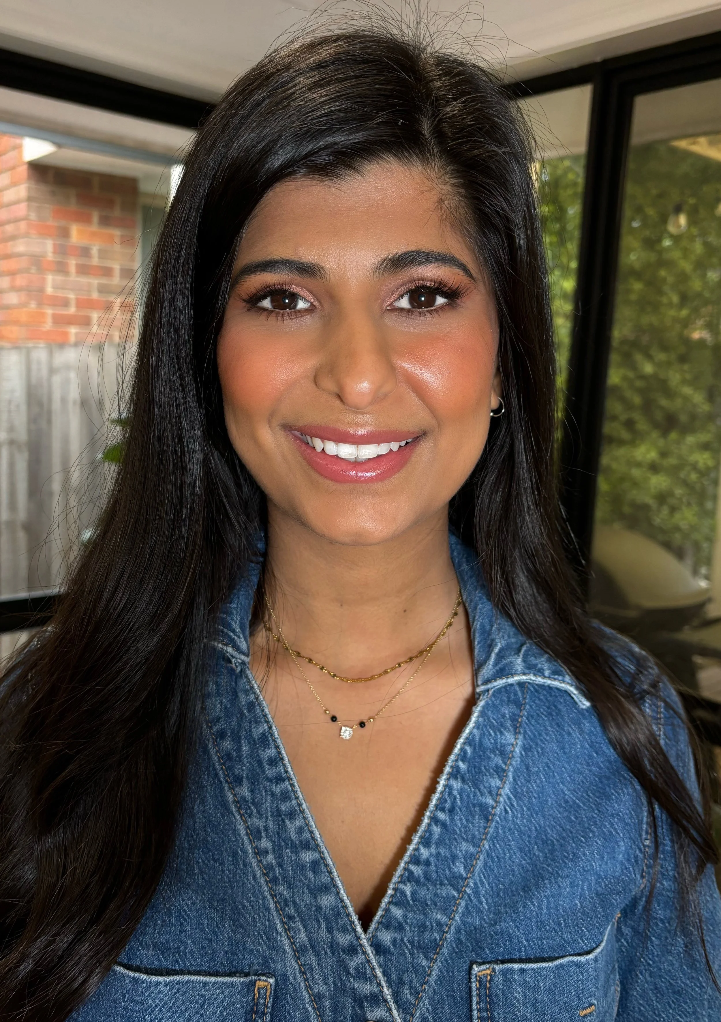 Woman smiling at the camera after having her makeup professionally applied for a special event
