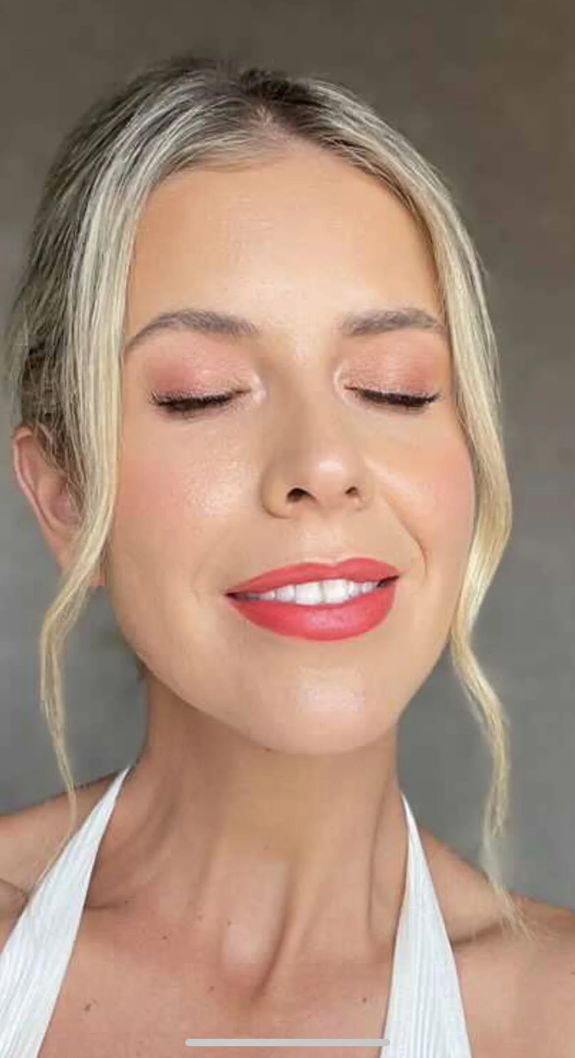 Woman with striking red lip and soft blush eyeshadow that has been professionally applied.