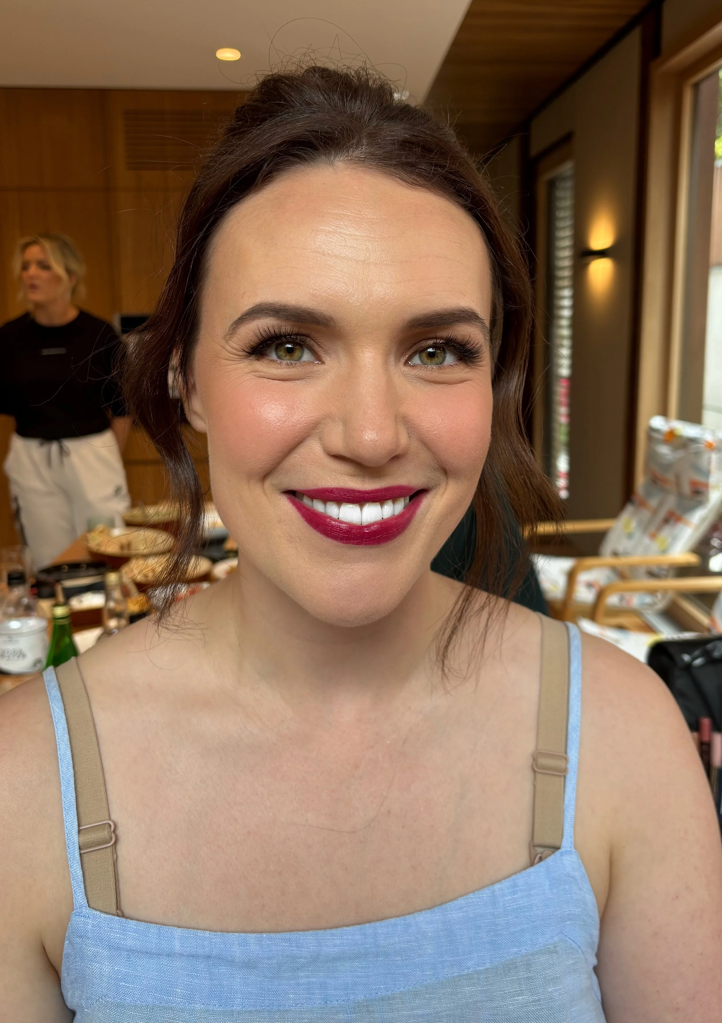 Professionally made up face including a deep red lip and soft curls in her hair. 