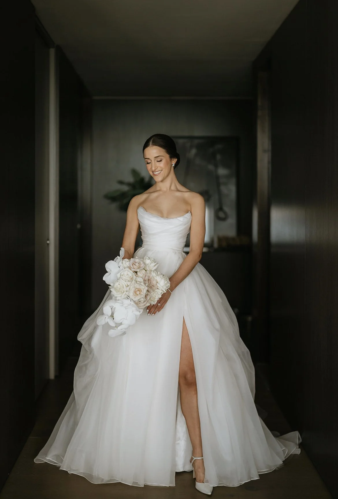 Bride wearing white strapless dress on a dark background
