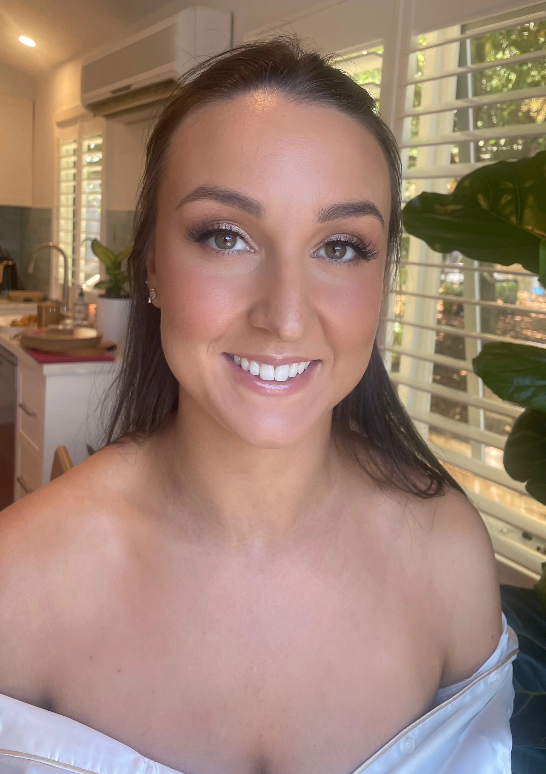 Smiling bride after having makeup professionally applied