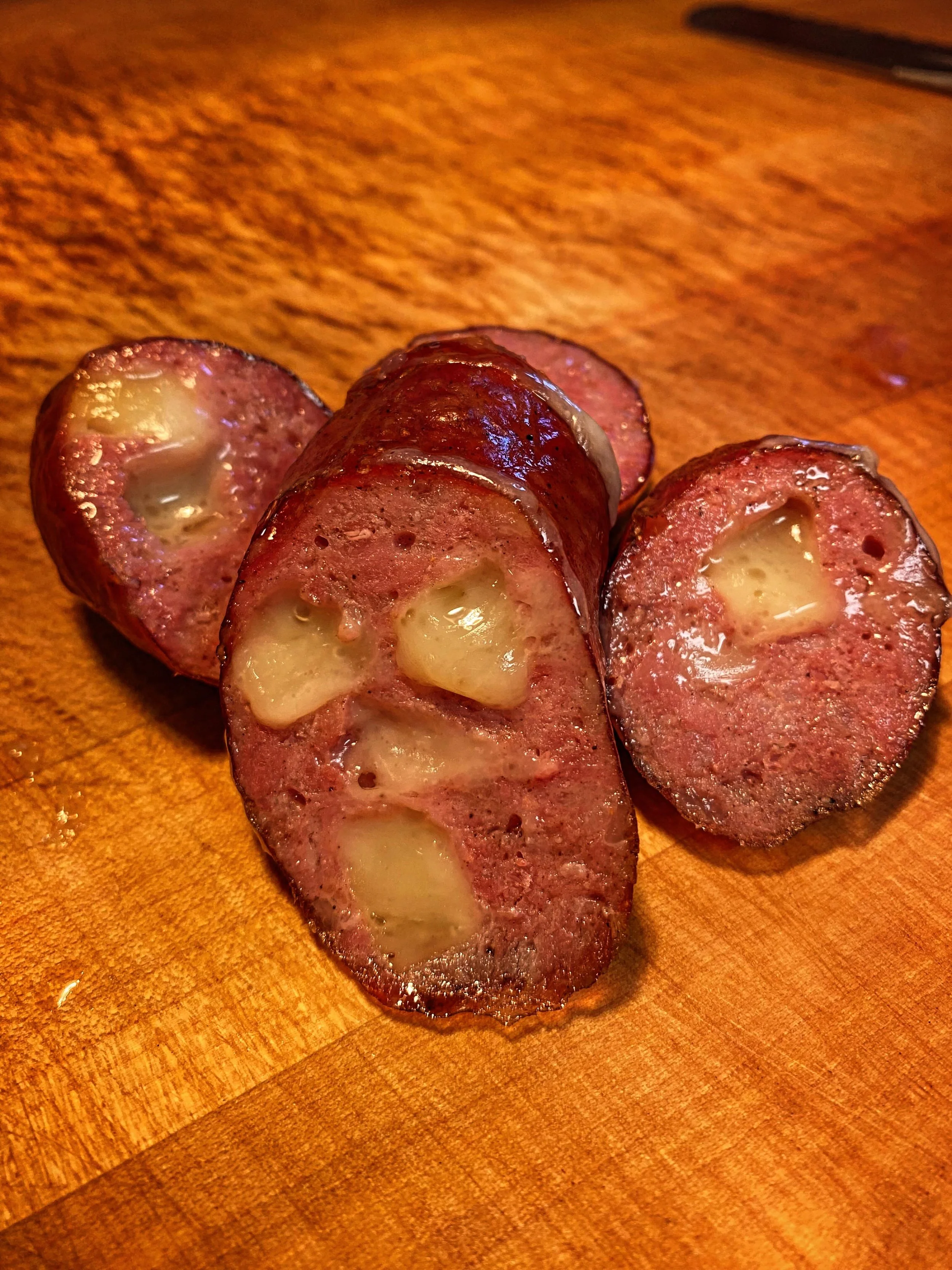 Swiss Cheese Knackers-
MAY SAUSAGE OF THE MONTH

A smoky blend of beef &amp; pork, simply spiced, loaded with Swiss cheese.

This link is basically a K&auml;sekrainer. An Austrian creation that is defined by its smoky, snappy, and cheesy nature. Emme