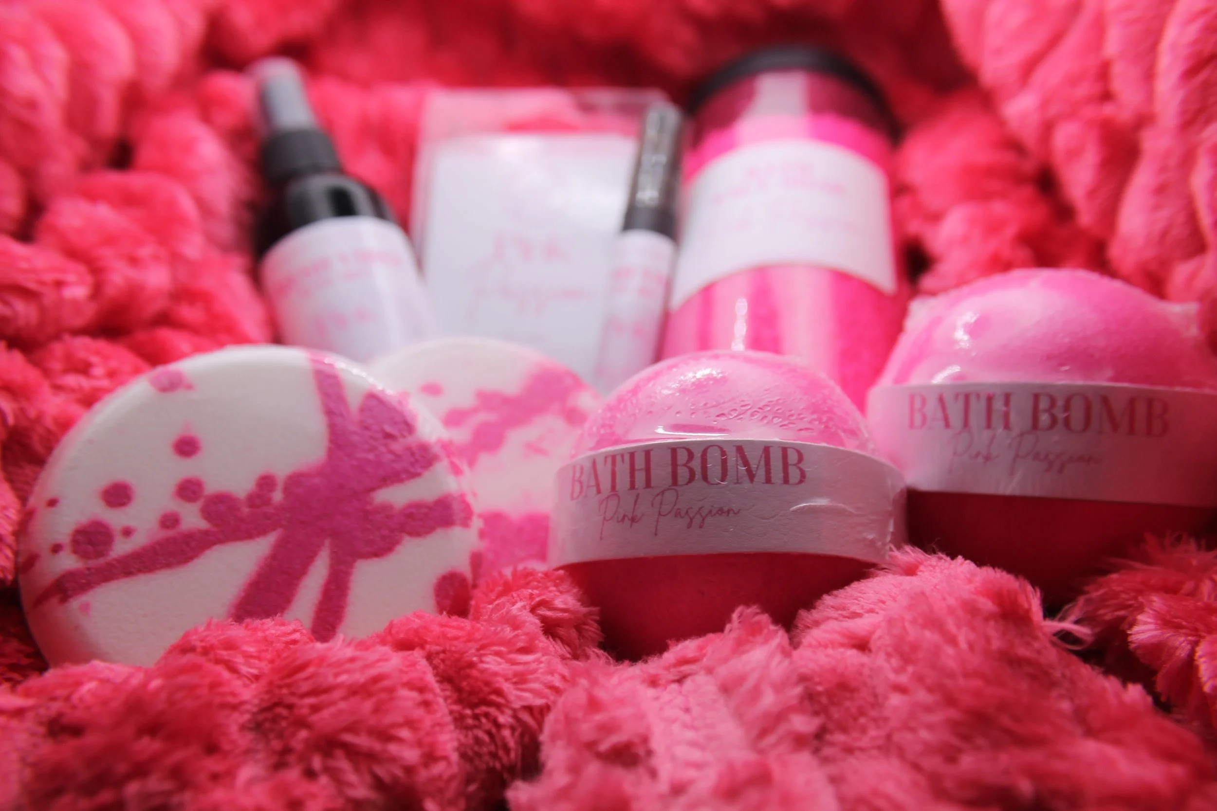 Pink Passion Gift Box with 2 bath bombs, 2 shower steamers, 2 wax melts, a bath salt, auto mist, and a cozy pink blanket, available in six scents for the ultimate self-care experience.