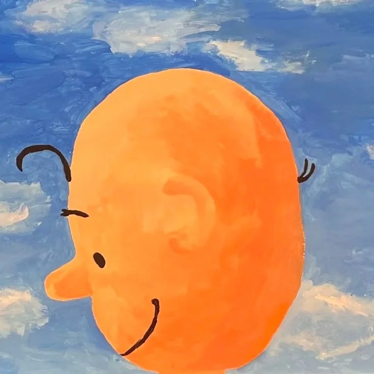 A smiling cartoon sun with a face, set against a blue sky with white clouds.