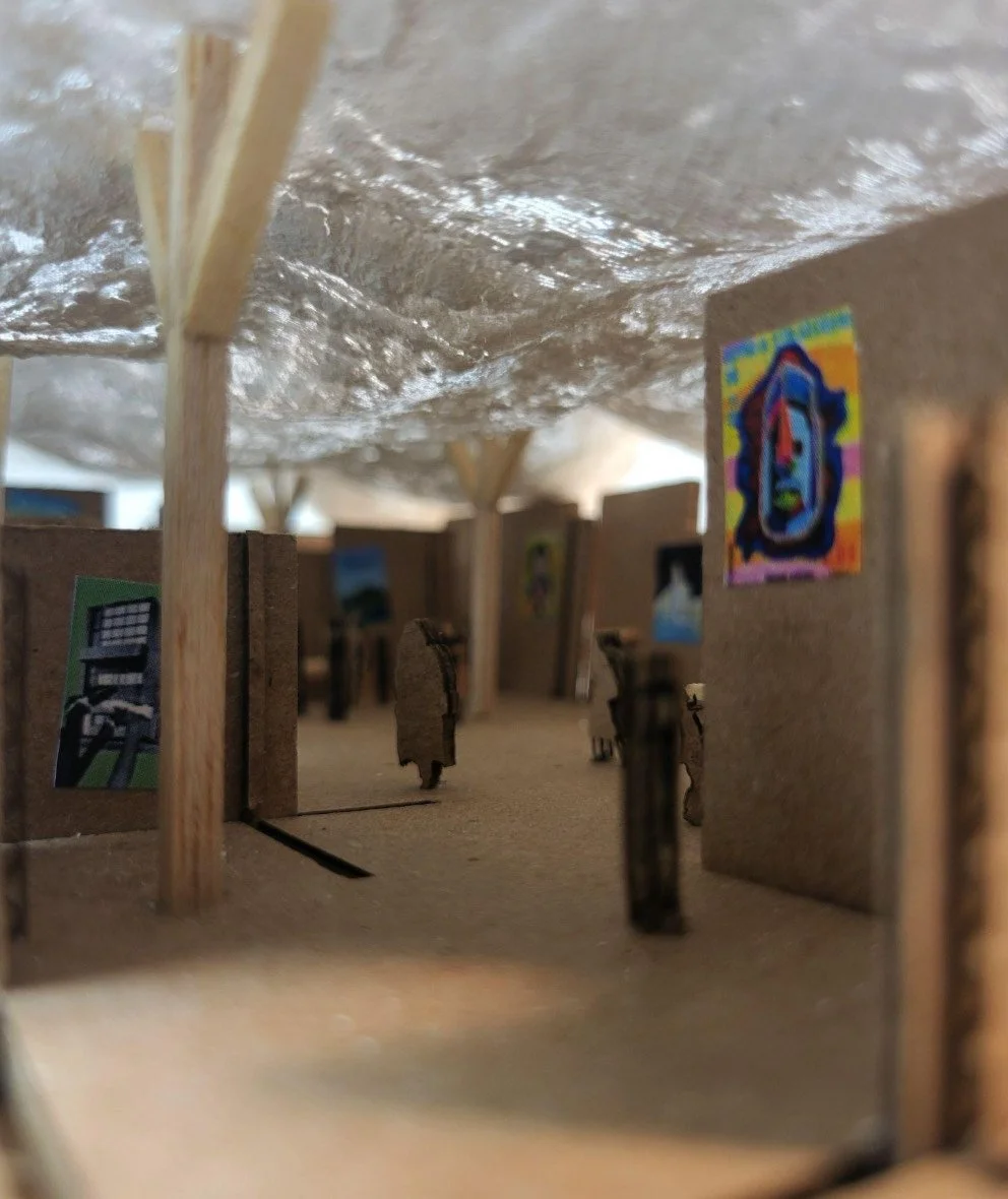 Miniature art scene of a crowded street with small cardboard cutouts of people and colorful artwork on the walls, under a reflective silver roof supported by wooden posts.