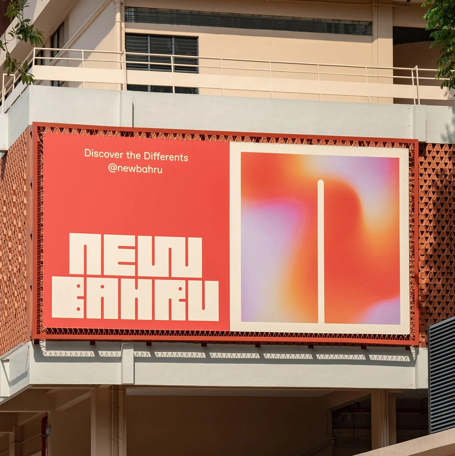 Outdoor billboard advertising a new exhibition with the message 'Discover the Different @newbahru' and abstract art in warm colors.