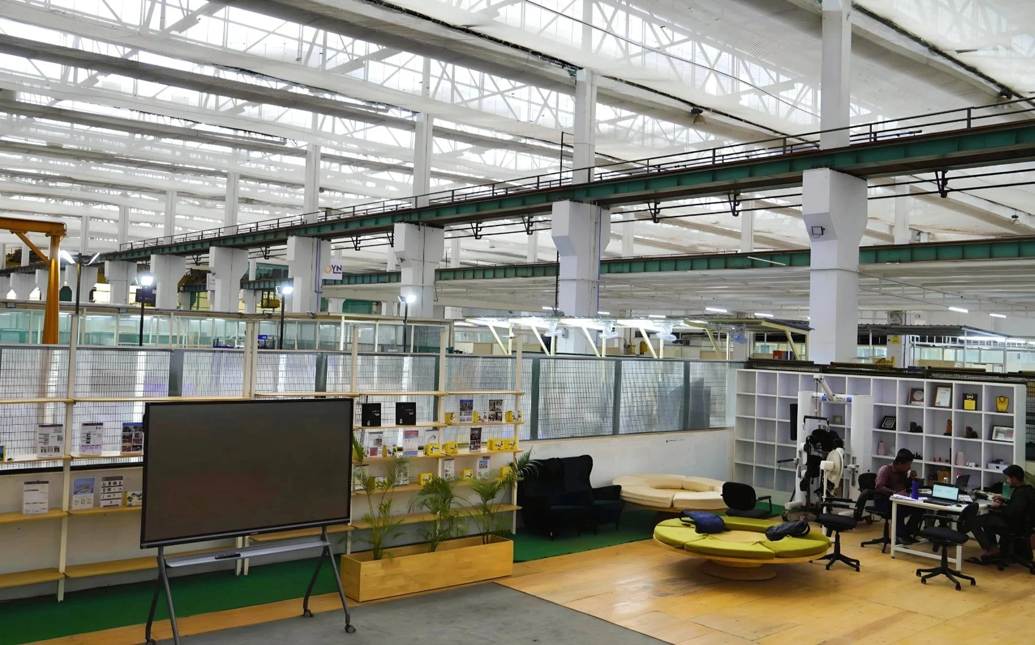 This image shows the common work space at ARTPARK, with people working on tables and the lounge area. 