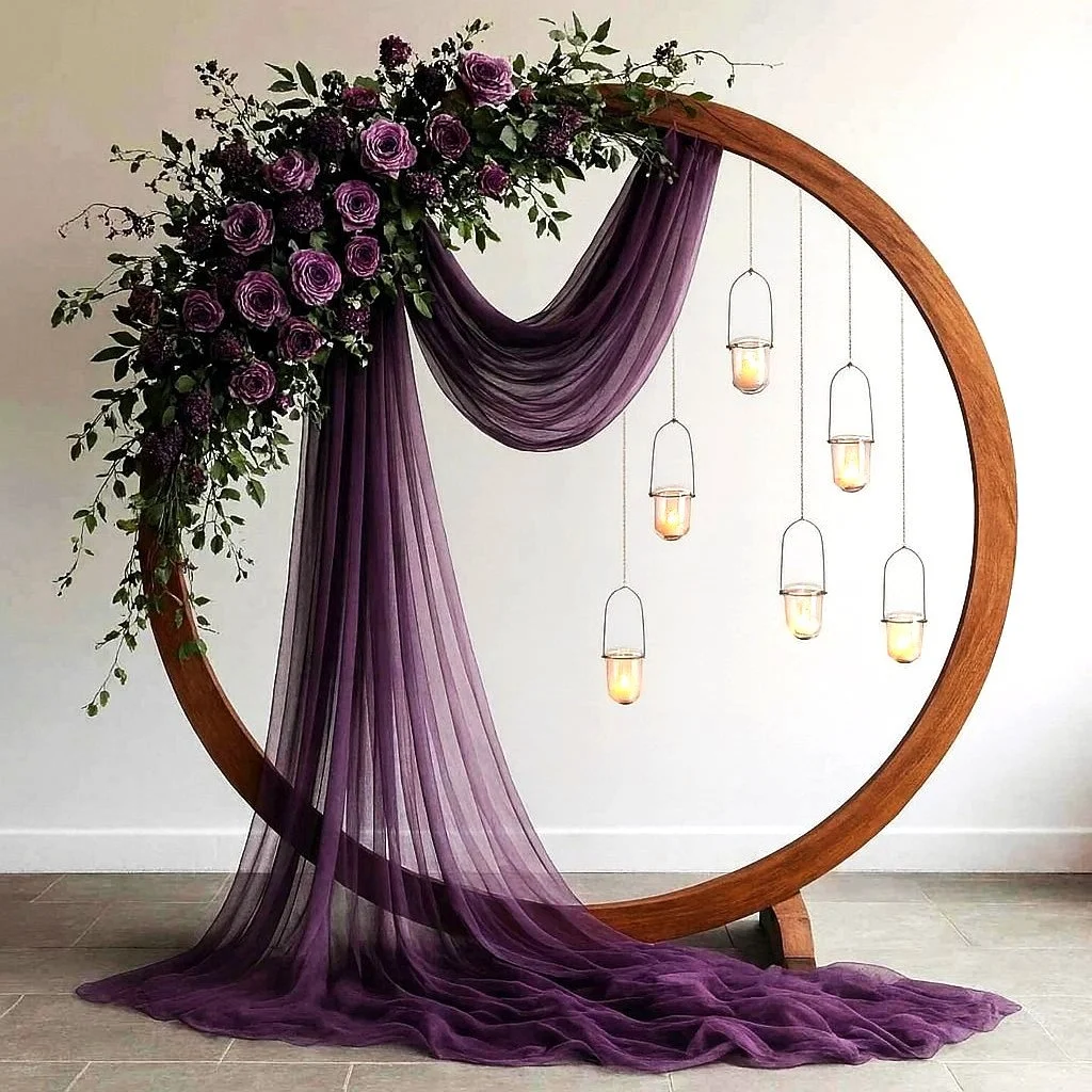 Bride and groom kissing under a draped wooden arch on a beach with the ocean in the background.  Beach ceremonies by interior scapes wedding officiant ventura county