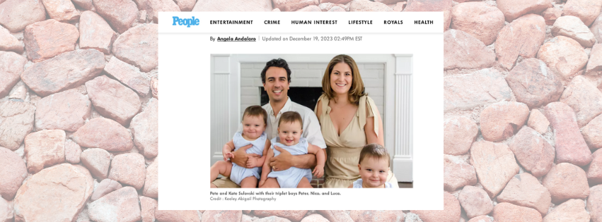 Family of five with two adults and triplets smiling indoors