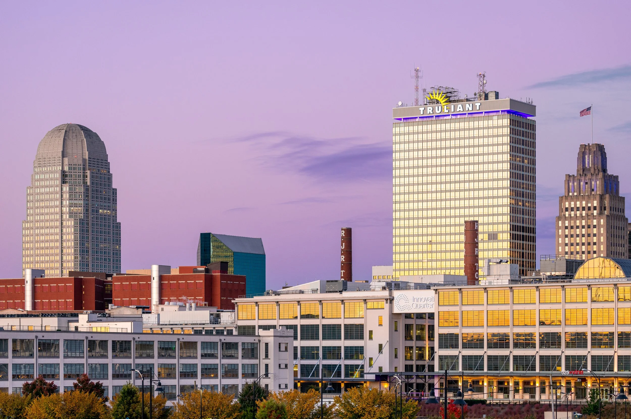 Winston-Salem skyline at sunset with iconic buildings and a purple sky.