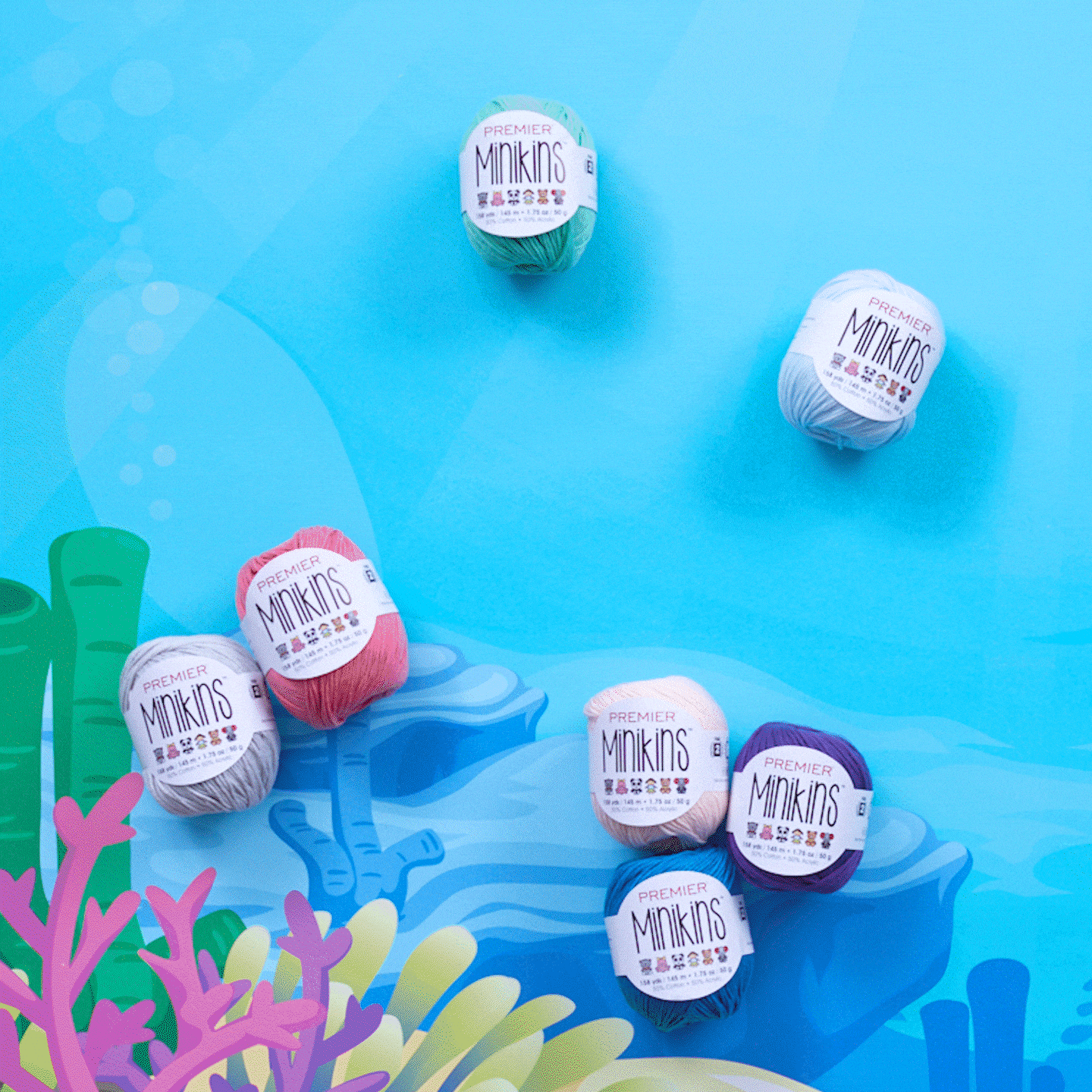 Colorful yarn balls labeled "Premier Minikins" on a sea-themed background with coral illustrations.