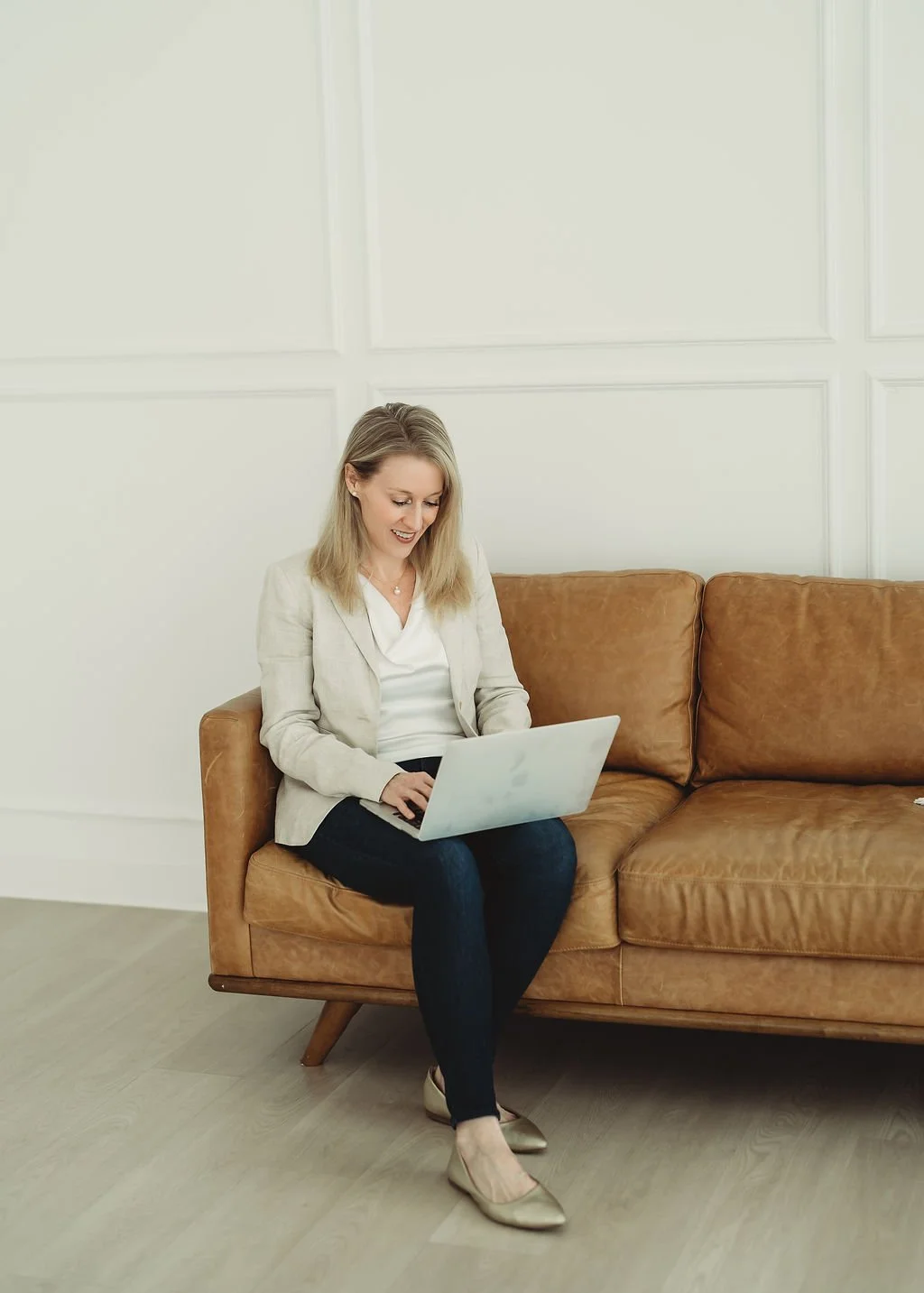 Woman seated on couch with laptop