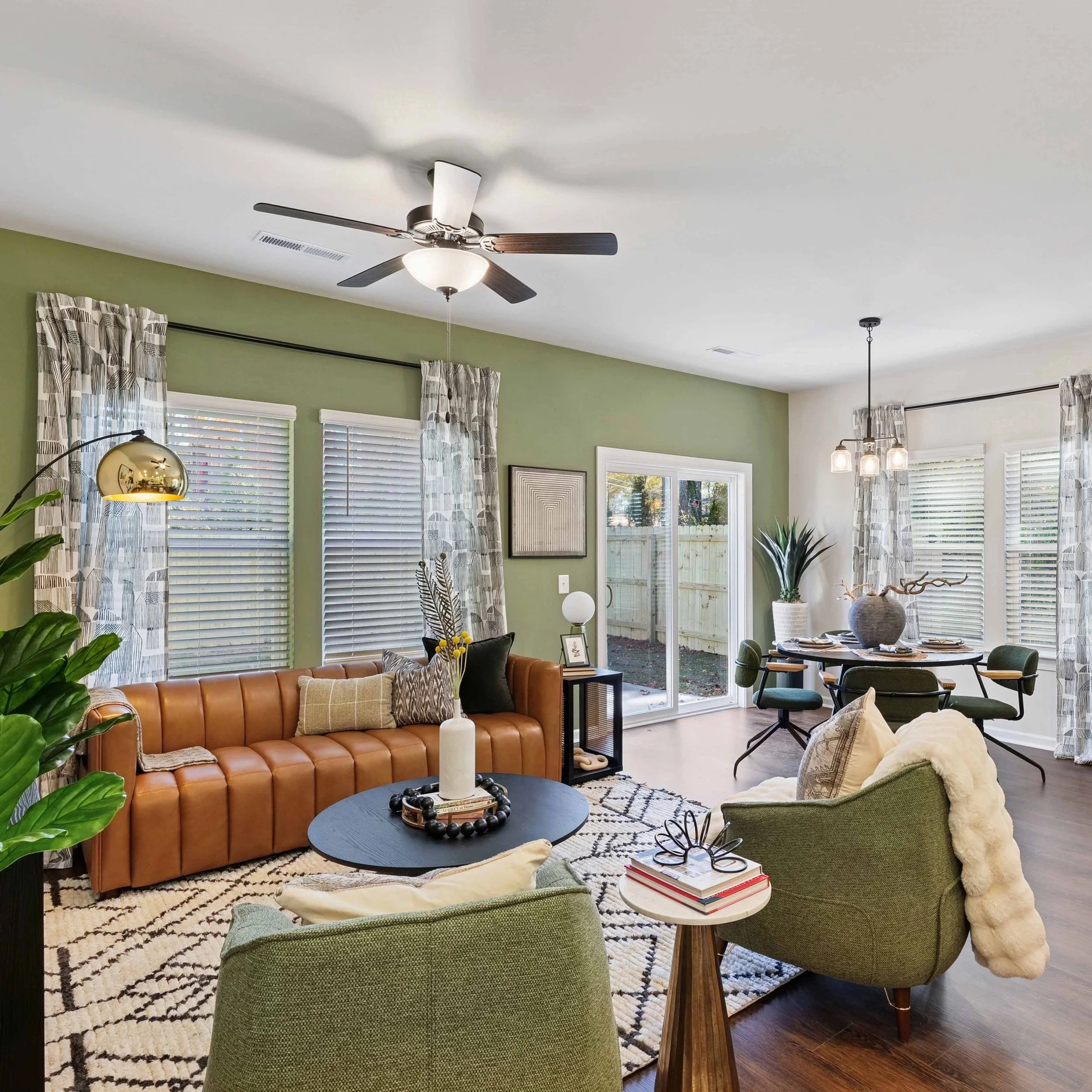 Kelly Ridge Townhomes, North Carolina | An image of a living room with green walls and warm, modern decor with mid-century vibes.