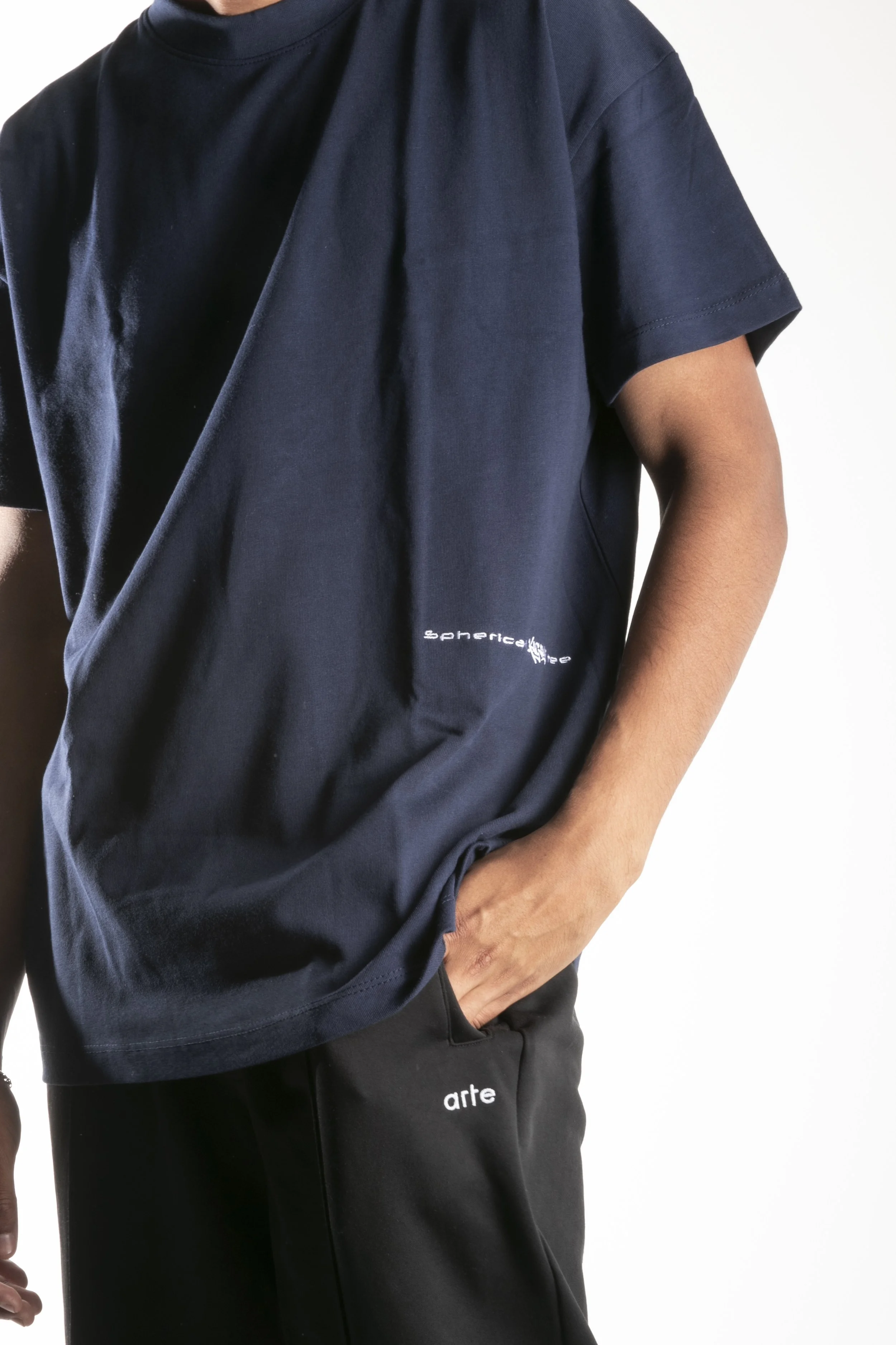 Personne portant un t-shirt noir et un pantalon noir avec des motifs et des mots en français.