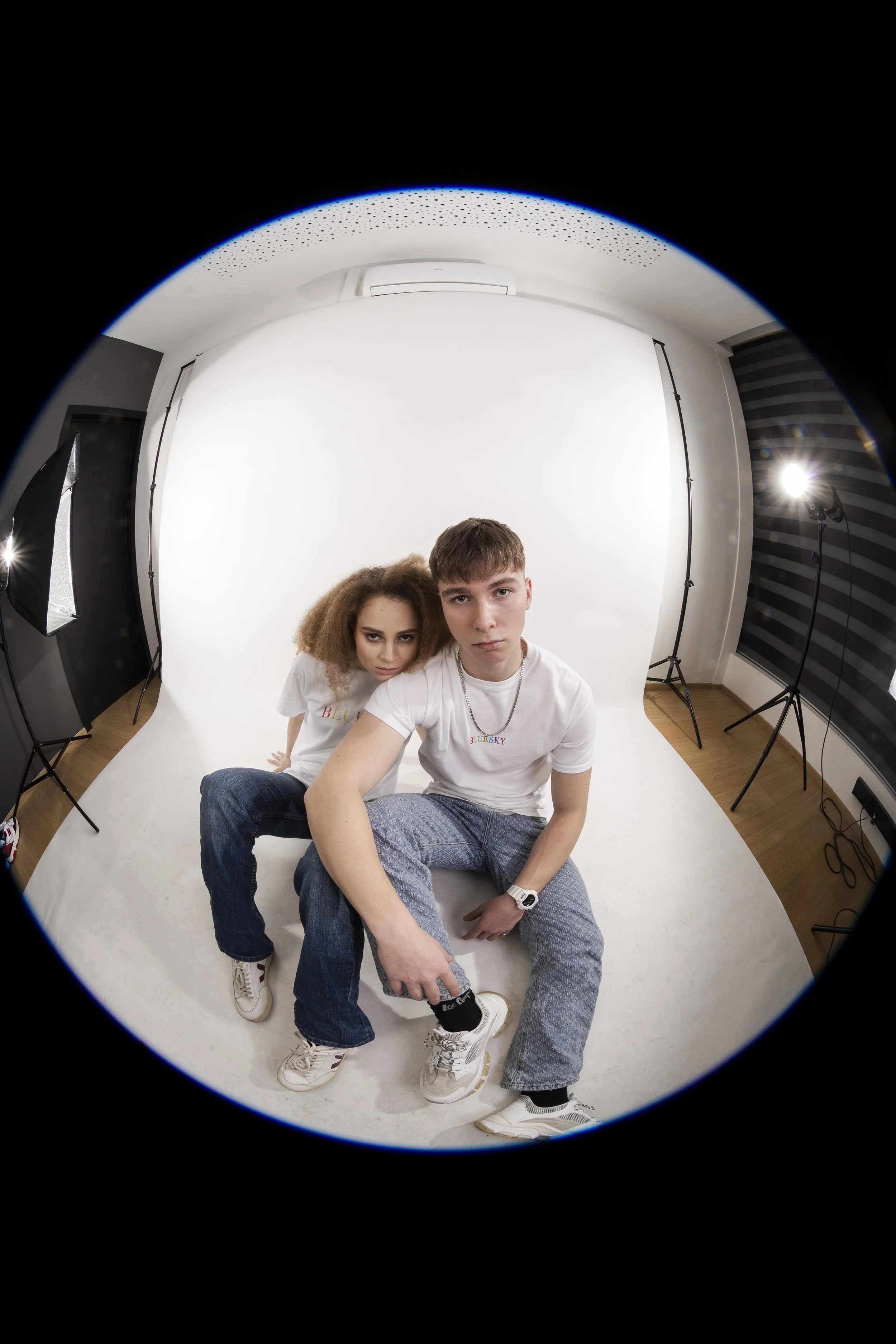 Deux modèles posent dans un studio photo avec un fond blanc et un éclairage professionnel pour la marque "BLUESKY"